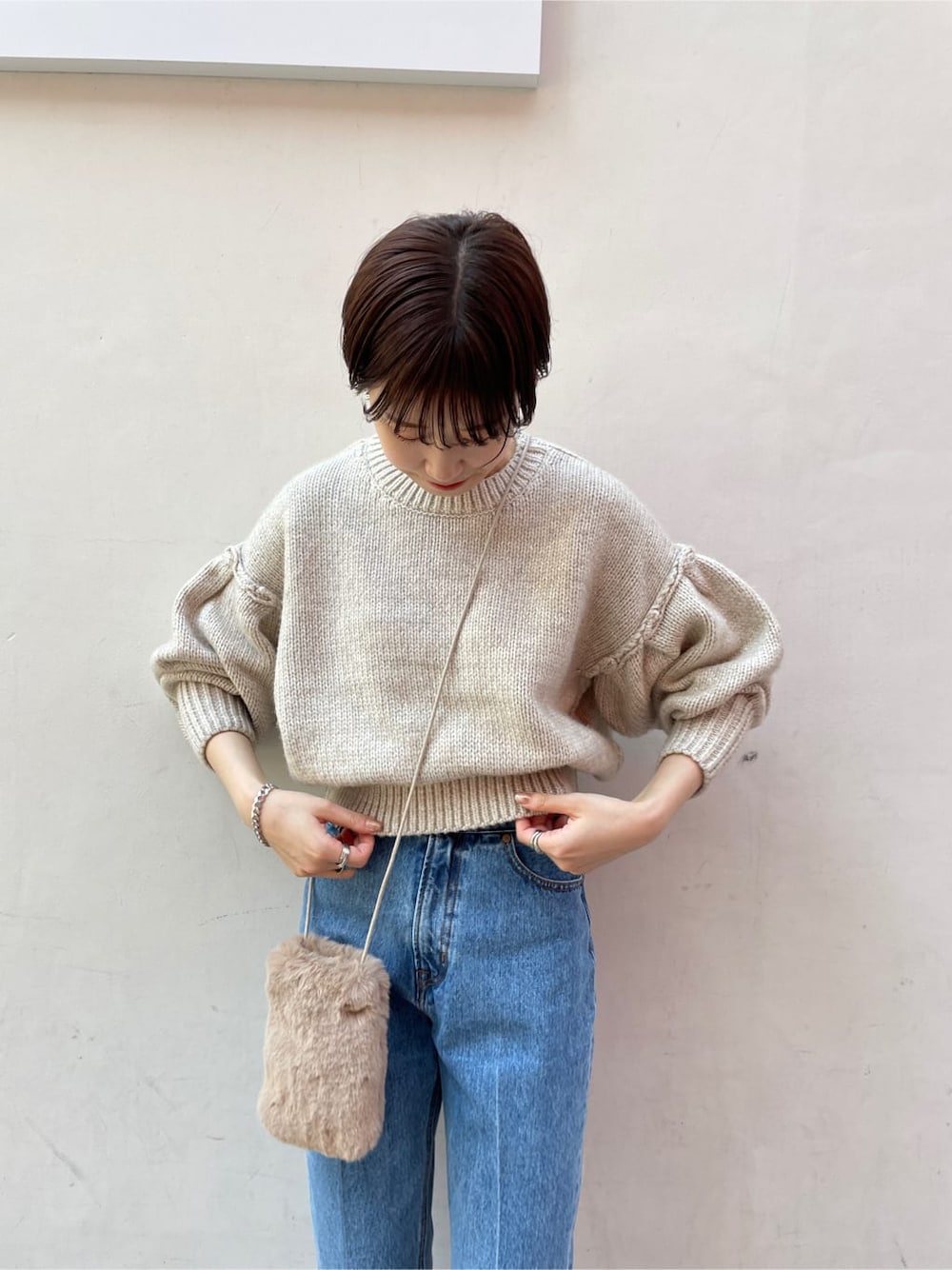 ブラック系のブーツ、ブルー系のデニムパンツ、ホワイト系のニット/セーターを着用したレディースの冬コーディネートの4枚目の写真