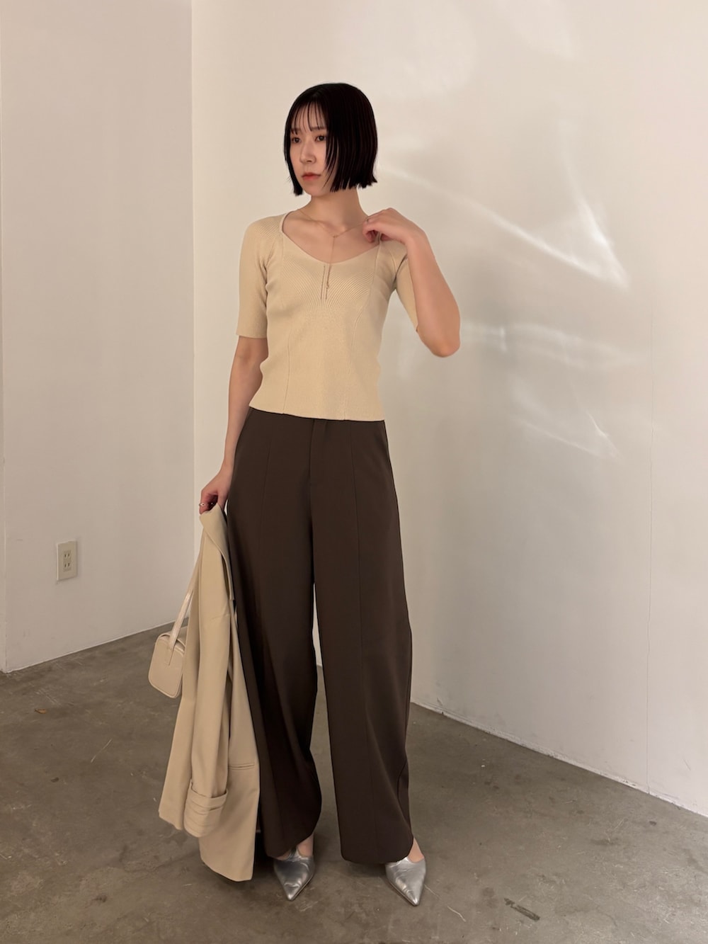 シルバー系のパンプス、ブラウン系のその他パンツ、ベージュ系のテーラードジャケットを着用したレディースの春コーディネートの4枚目の写真