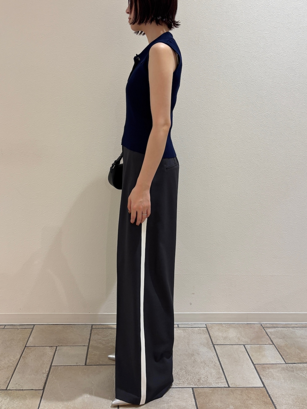 グレー系のその他パンツ、シルバー系のパンプス、ブラック系のハンドバッグを着用したレディースの夏コーディネートの2枚目の写真