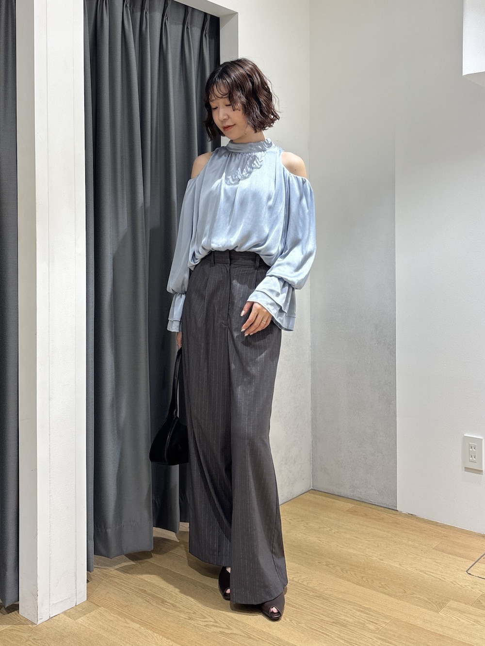 ブルー系のシャツ/ブラウス、グレー系のその他パンツ、ブラック系のハンドバッグを着用したレディースの秋コーディネートの2枚目の写真