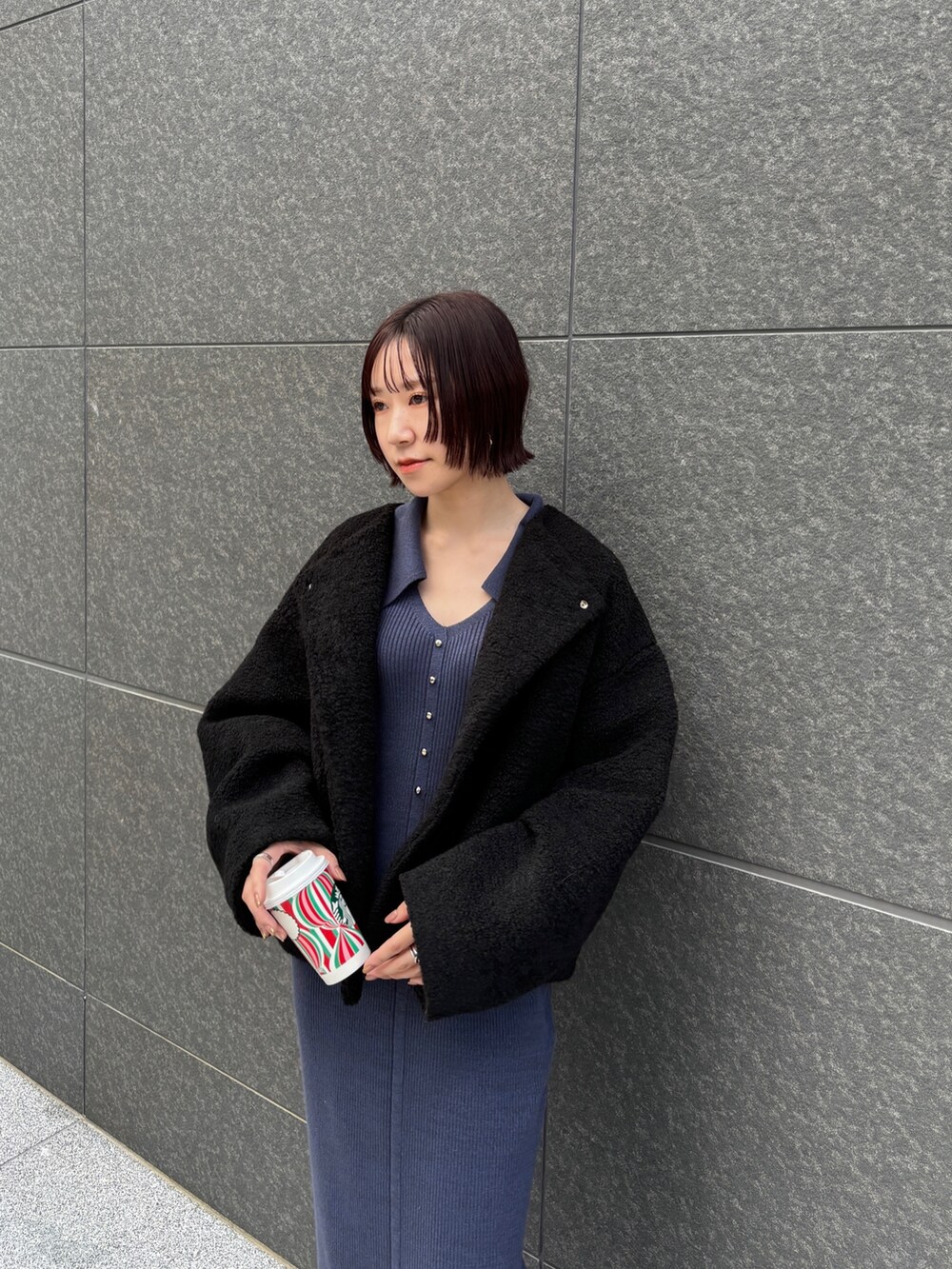 ブルー系のワンピース、ブラック系のブルゾンを着用したレディースの秋コーディネートの5枚目の写真