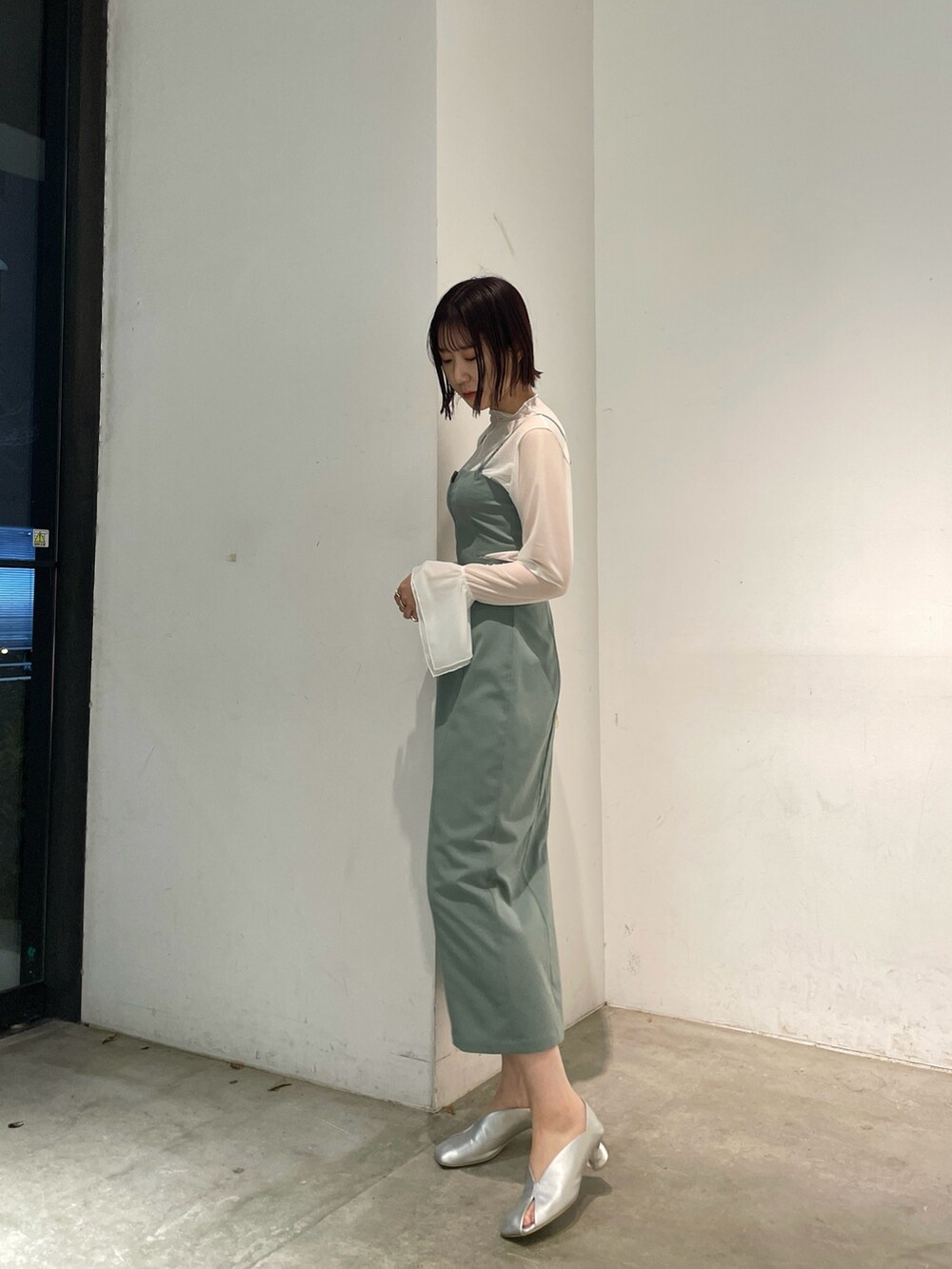 シルバー系のパンプス、グリーン系のワンピースを着用したレディースの春コーディネートの3枚目の写真