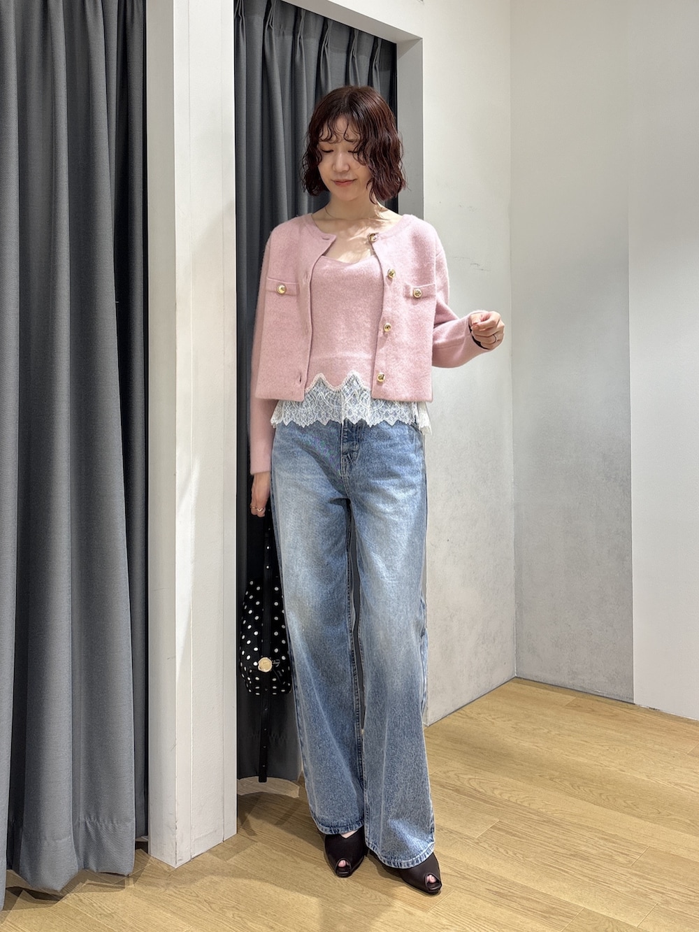 ブルー系のデニムパンツ、ピンク系のキャミソール、ピンク系のノーカラージャケットを着用したレディースの秋コーディネートの2枚目の写真