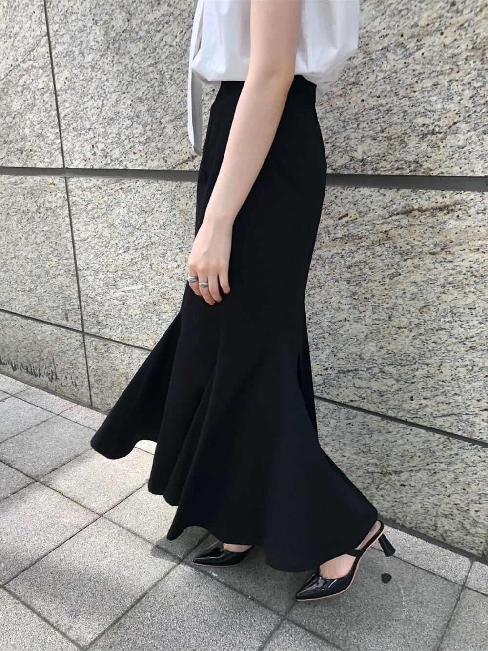 ブラック系のその他シューズ、ホワイト系のシャツ/ブラウス、ブラック系のスカートを着用したレディースの夏コーディネートの3枚目の写真