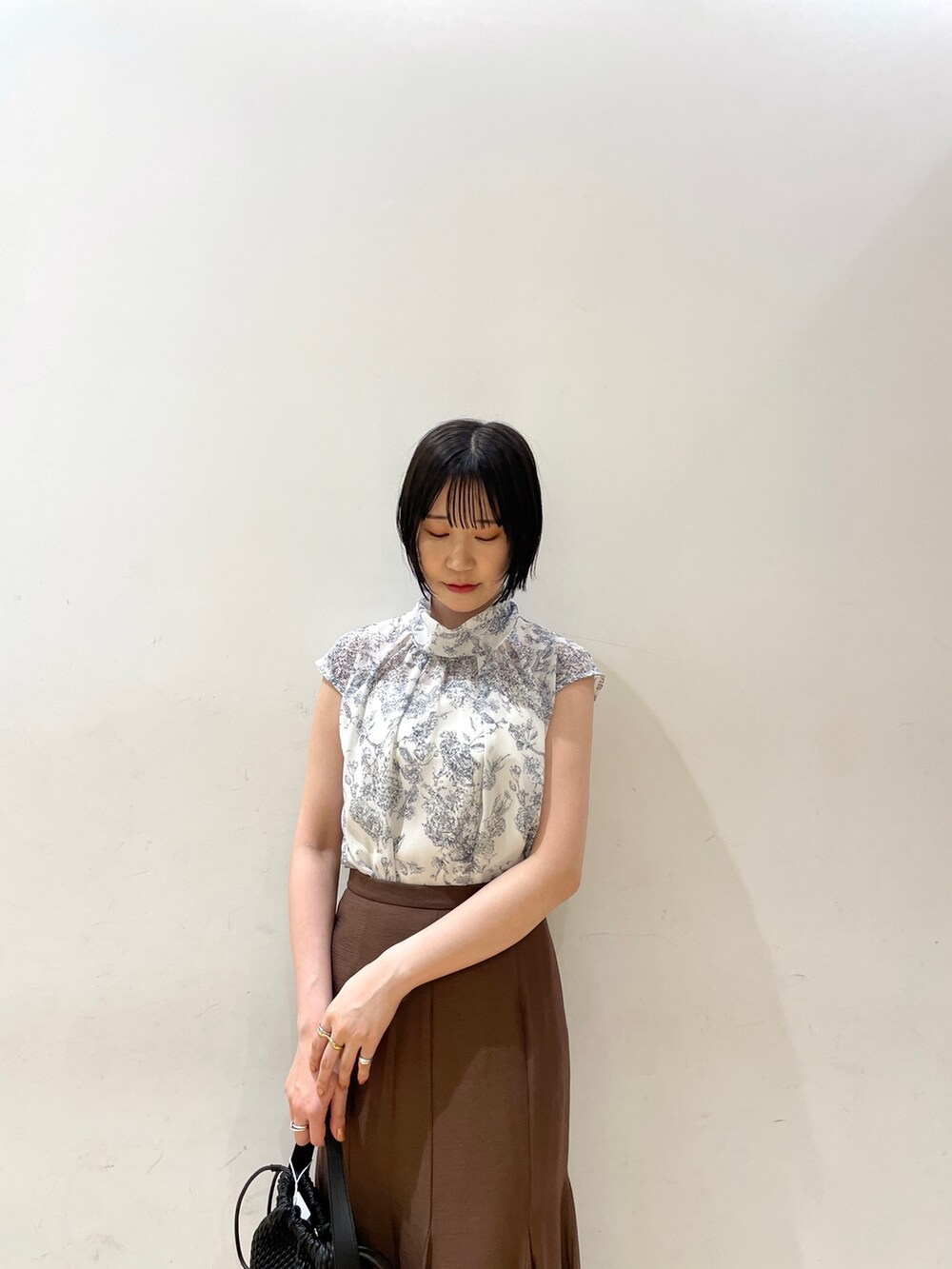 ブラウン系のスカート、ブラウン系のサンダル、ブルー系のシャツ/ブラウスを着用したレディースの夏コーディネートの7枚目の写真