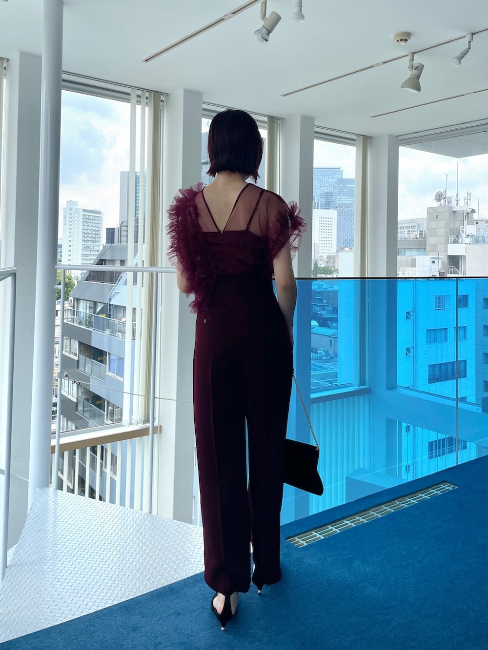 レッド系のパンツドレスを着用したレディースの春コーディネートの4枚目の写真