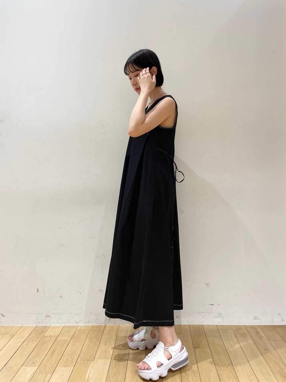 ブラック系のワンピース、ホワイト系のハンドバッグ、ホワイト系のネックレスを着用したレディースの夏コーディネートの5枚目の写真