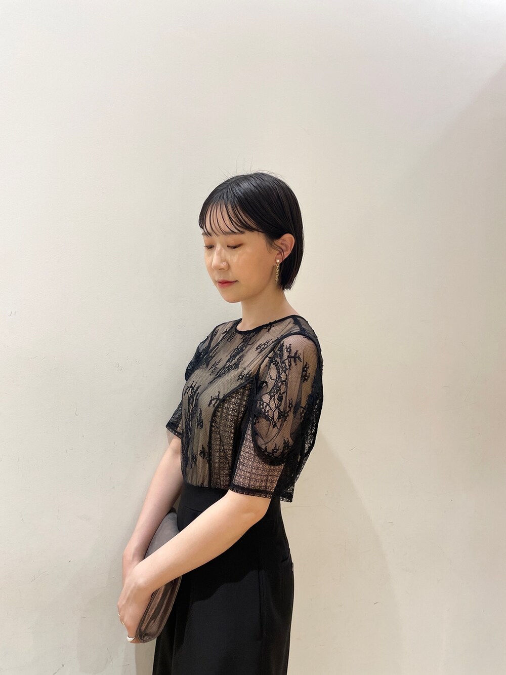 シルバー系のハンドバッグ、シルバー系のパンプス、ブラック系のパンツドレスを着用したレディースの夏コーディネートの7枚目の写真