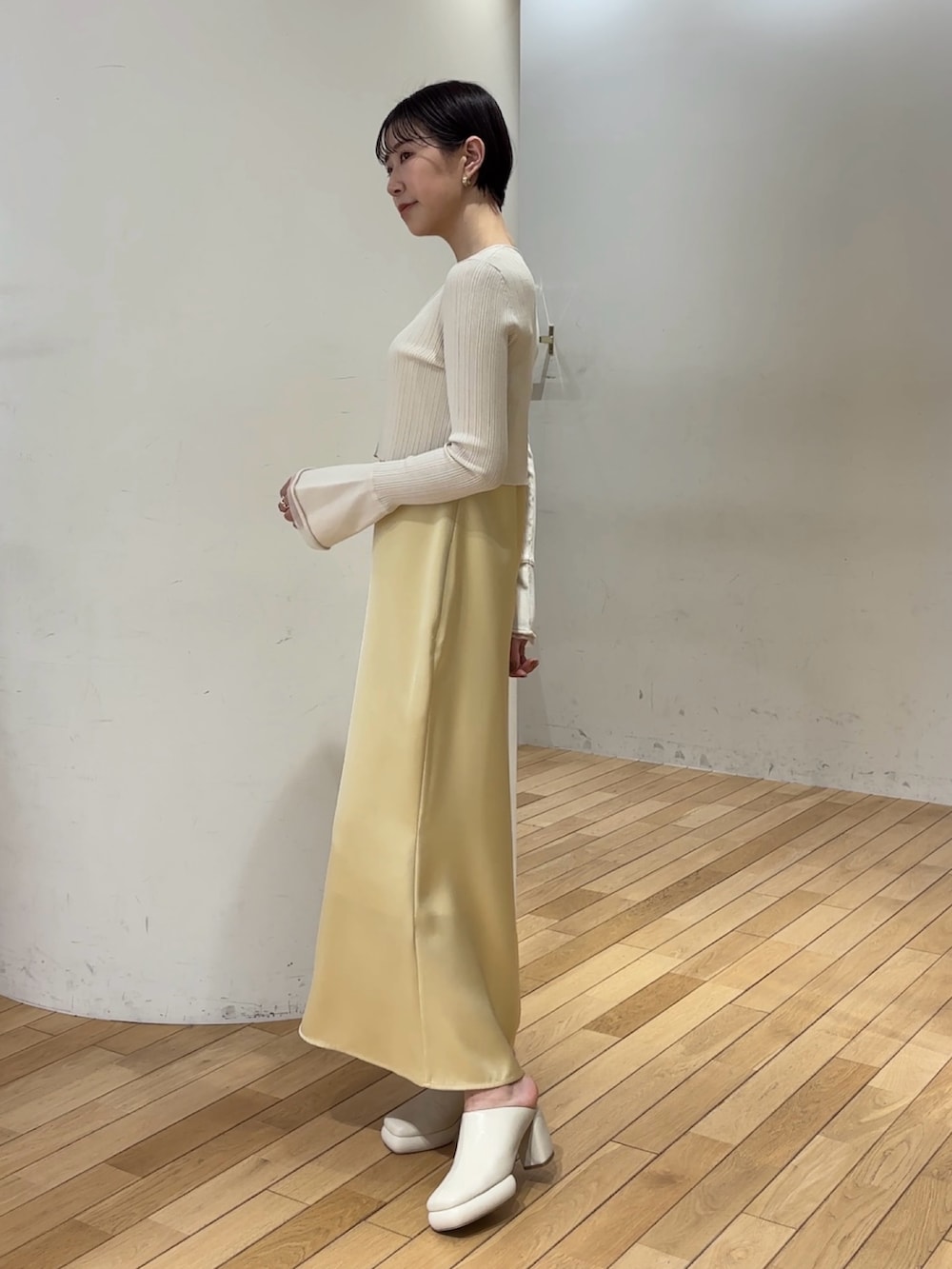 ホワイト系のワンピース、ホワイト系のサンダル、ブルー系のアンサンブルを着用したレディースの春コーディネートの3枚目の写真