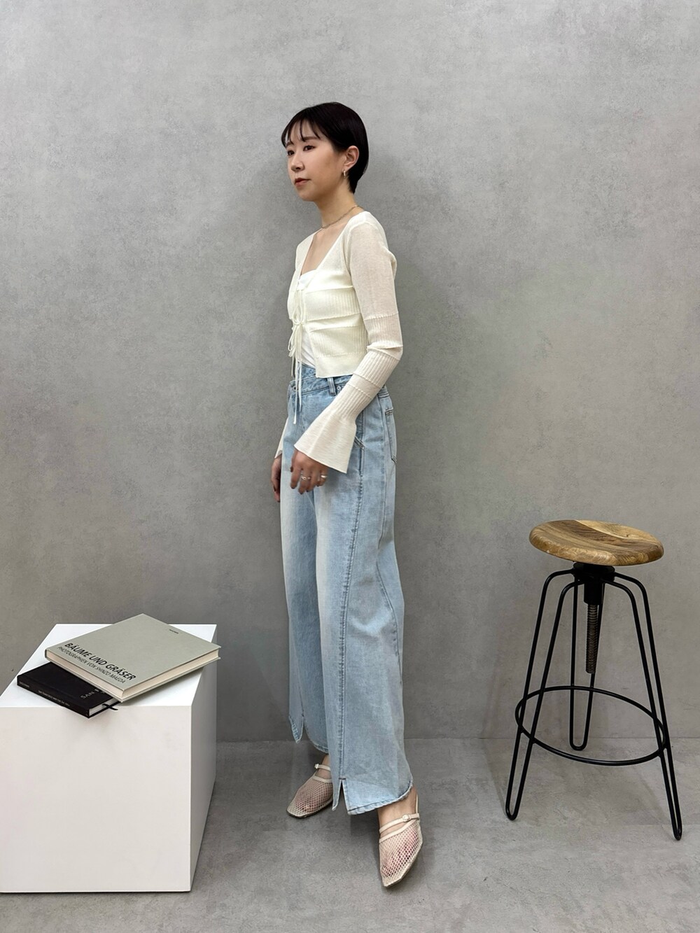 ブルー系のデニムパンツ、ホワイト系のカーディガン/ボレロ、ホワイト系のサンダルを着用したレディースの春コーディネートの3枚目の写真