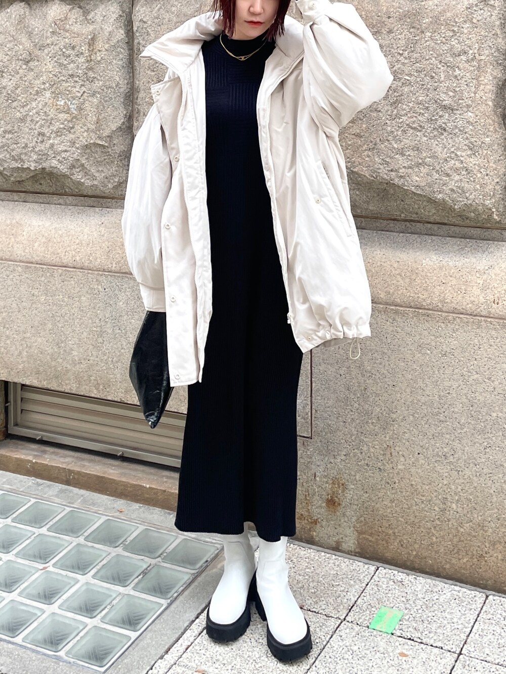 ホワイト系のダウンジャケット/コート、ブラック系のワンピースを着用したレディースの冬コーディネートの2枚目の写真