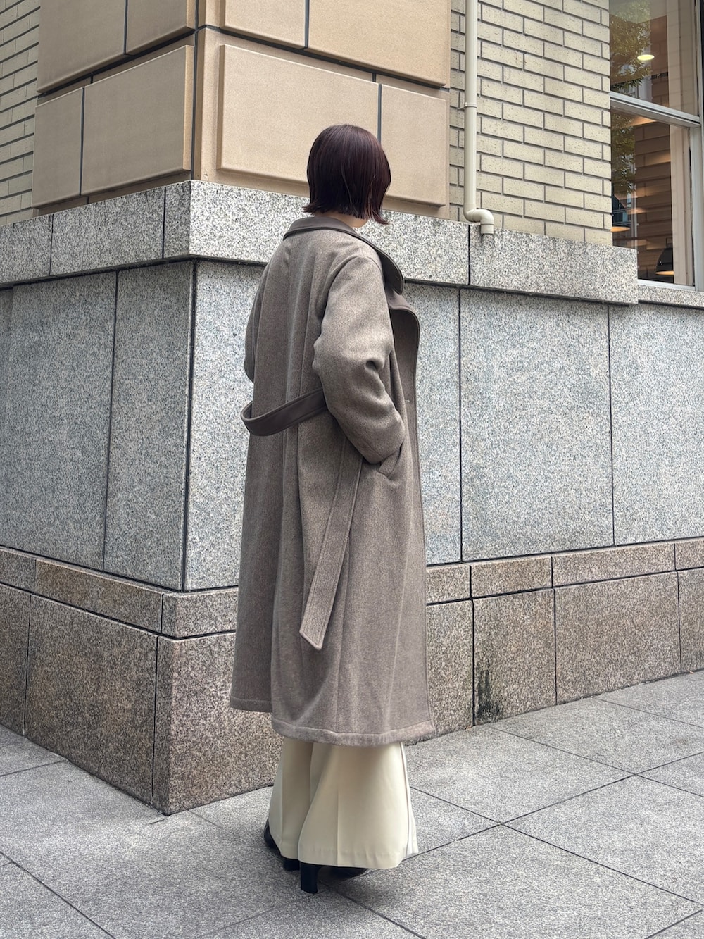 ベージュ系のその他パンツ、ブラウン系のチェスターコート、イエロー系のカーディガン/ボレロを着用したレディースの秋コーディネートの3枚目の写真