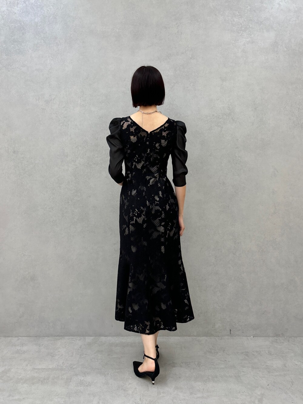 ブラック系のドレス、ブラック系のパンプスを着用したレディースの秋コーディネートの3枚目の写真