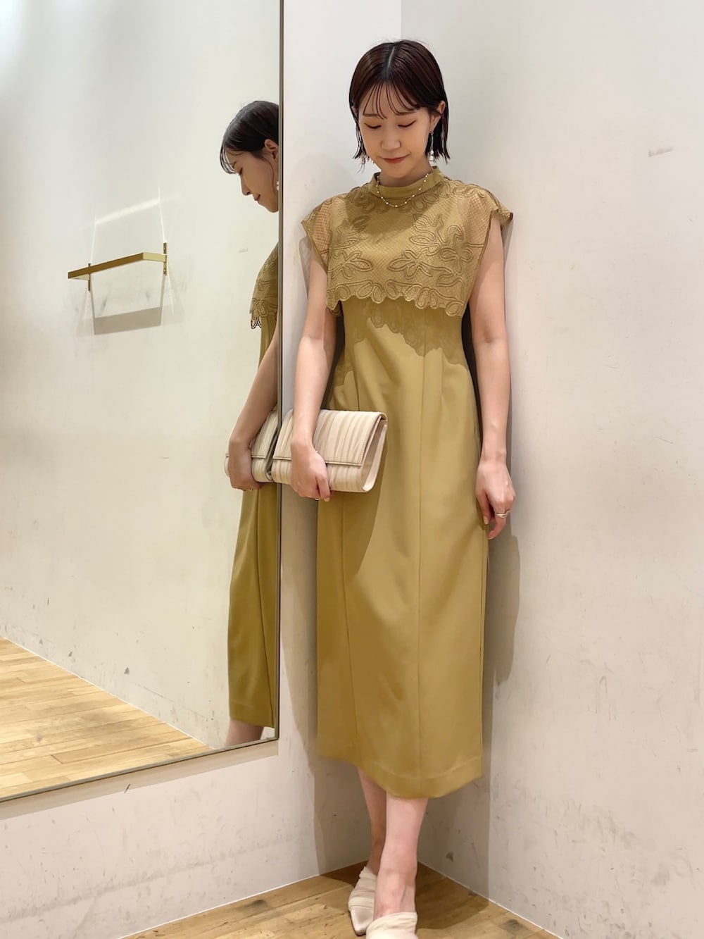 ベージュ系のドレス、ベージュ系のハンドバッグ、ベージュ系のパンプスを着用したレディースの秋コーディネートの4枚目の写真