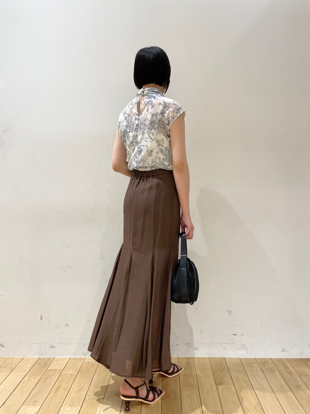 ブラウン系のスカート、ブラウン系のサンダル、ブルー系のシャツ/ブラウスを着用したレディースの夏コーディネートの4枚目の写真