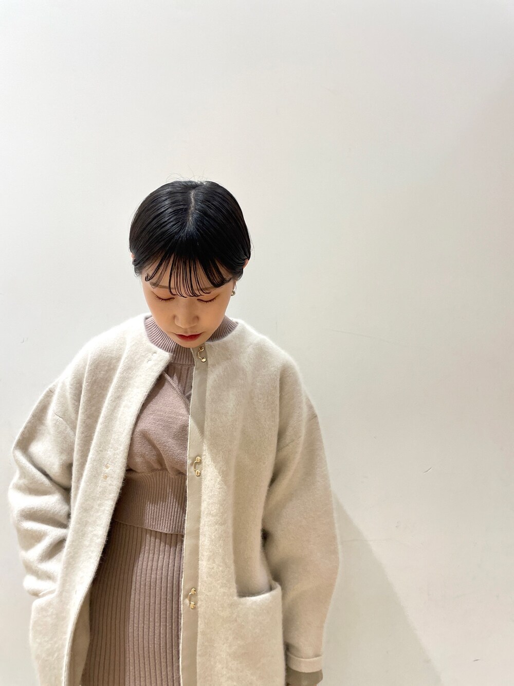 ホワイト系のカーディガン/ボレロ、ベージュ系のワンピース、ホワイト系のハンドバッグを着用したレディースの冬コーディネートの5枚目の写真