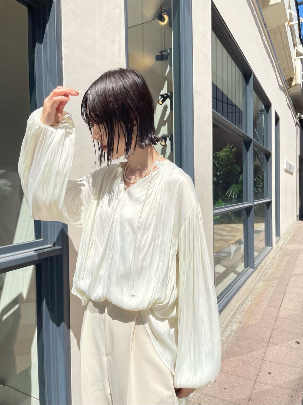 ホワイト系のシャツ/ブラウス、ホワイト系のその他シューズ、ベージュ系のその他アウターを着用したレディースの秋コーディネートの3枚目の写真