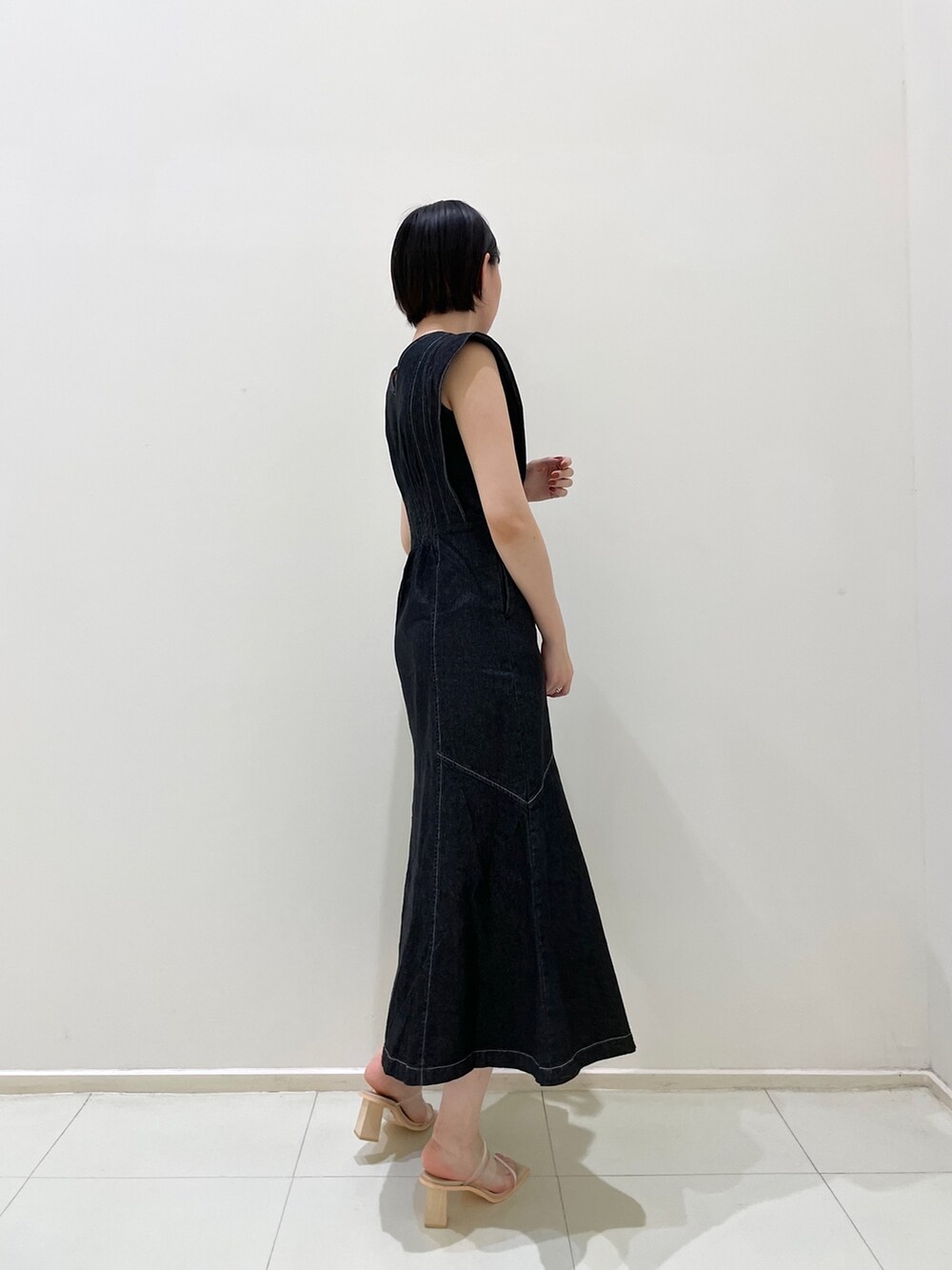 ブラック系のワンピース、ベージュ系のカーディガン/ボレロ、その他のサンダルを着用したレディースの春コーディネートの5枚目の写真