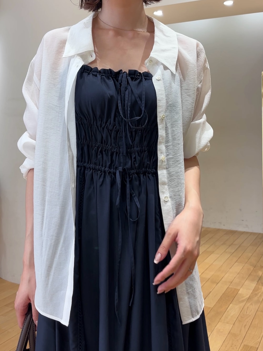 ブルー系のワンピース、ホワイト系のシャツ/ブラウス、ブラウン系のハンドバッグを着用したレディースの夏コーディネートの4枚目の写真