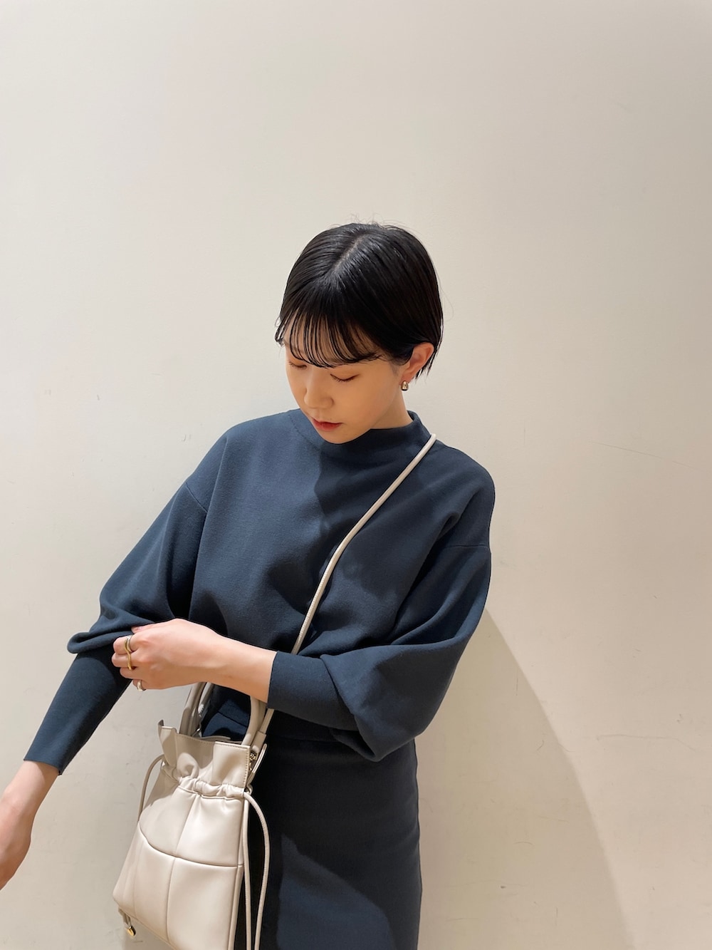 グリーン系のスカート、グリーン系のニット/セーター、ブラック系のブーツを着用したレディースの冬コーディネートの6枚目の写真