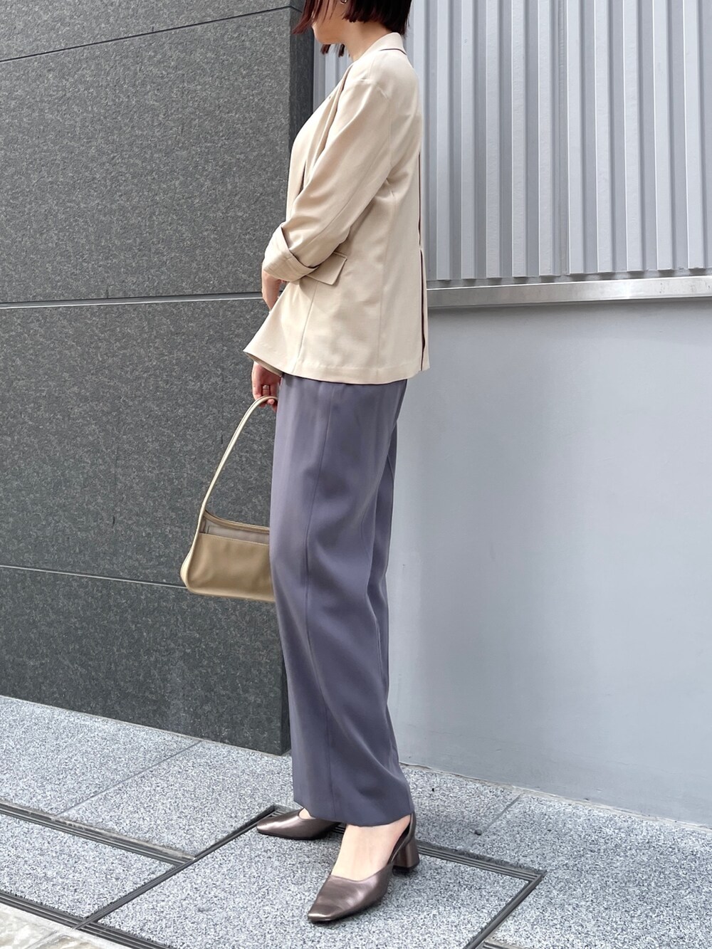 グレー系のパンツドレス、その他のパンプス、ベージュ系のテーラードジャケットを着用したレディースの春コーディネートの4枚目の写真