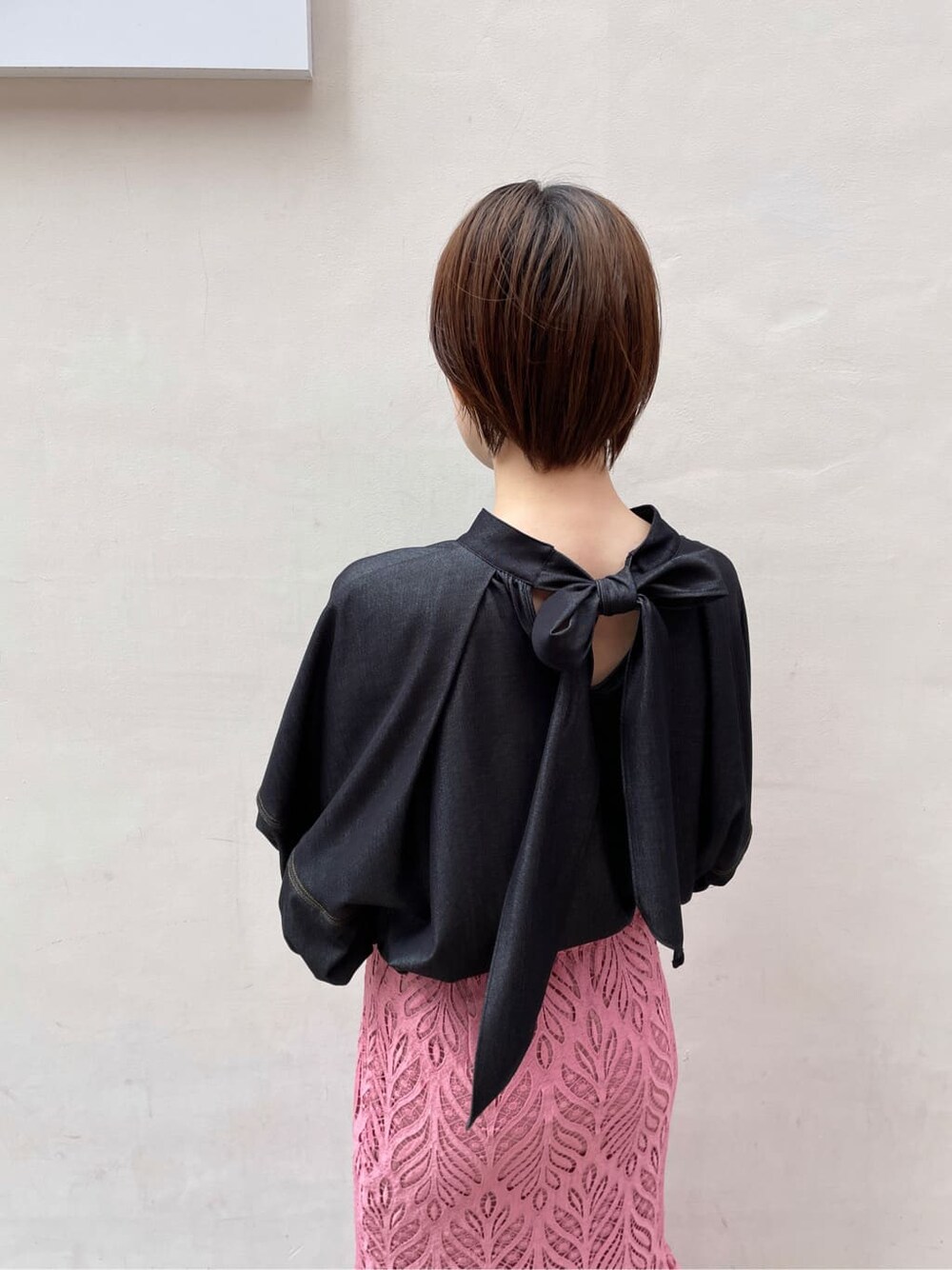 ブラック系のハンドバッグ、ブラック系のサンダル、ピンク系のスカートを着用したレディースの春コーディネートの8枚目の写真