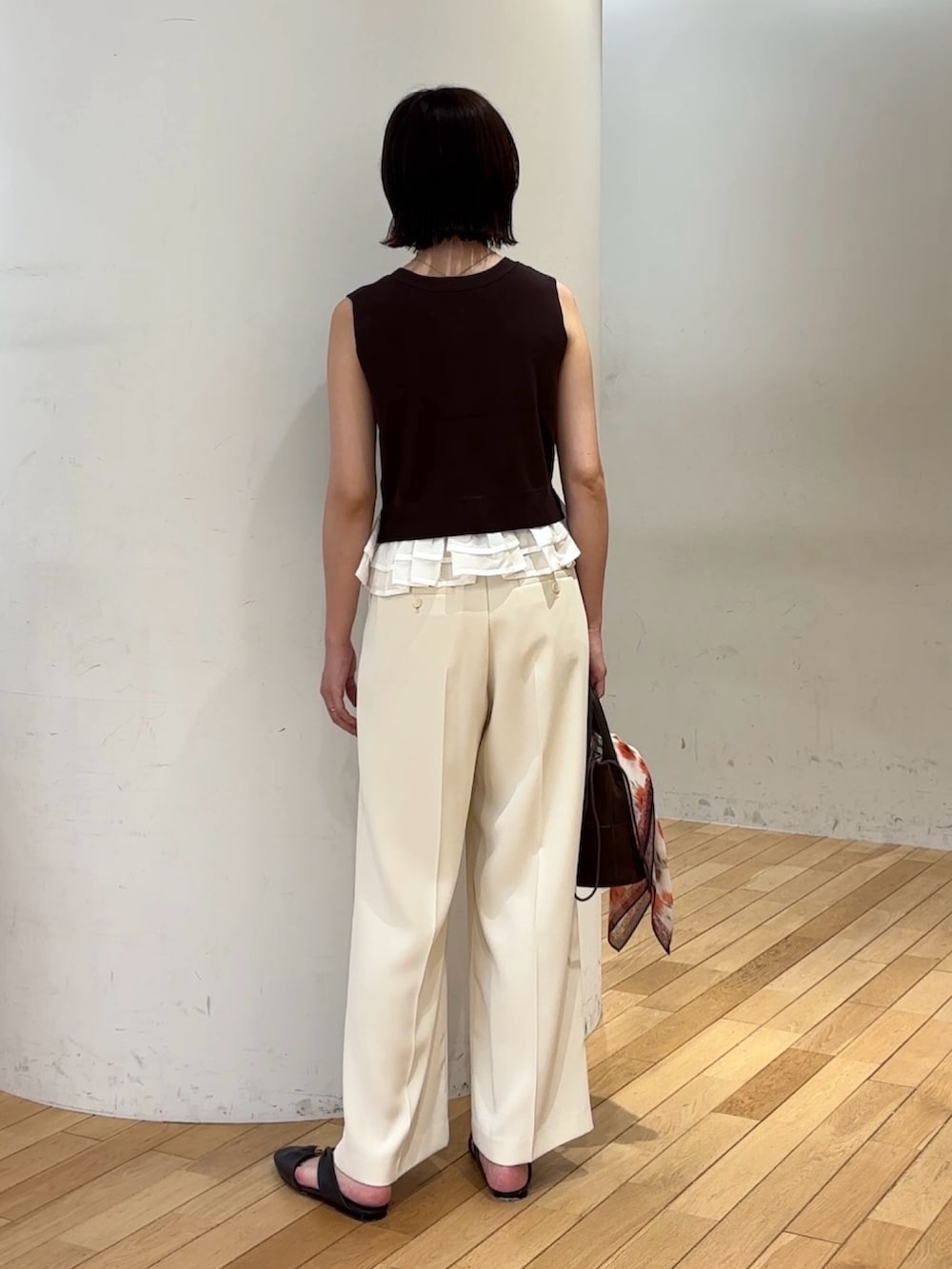 ブラウン系のニット/セーター、ホワイト系のその他パンツ、ブラウン系のハンドバッグを着用したレディースの夏コーディネートの3枚目の写真