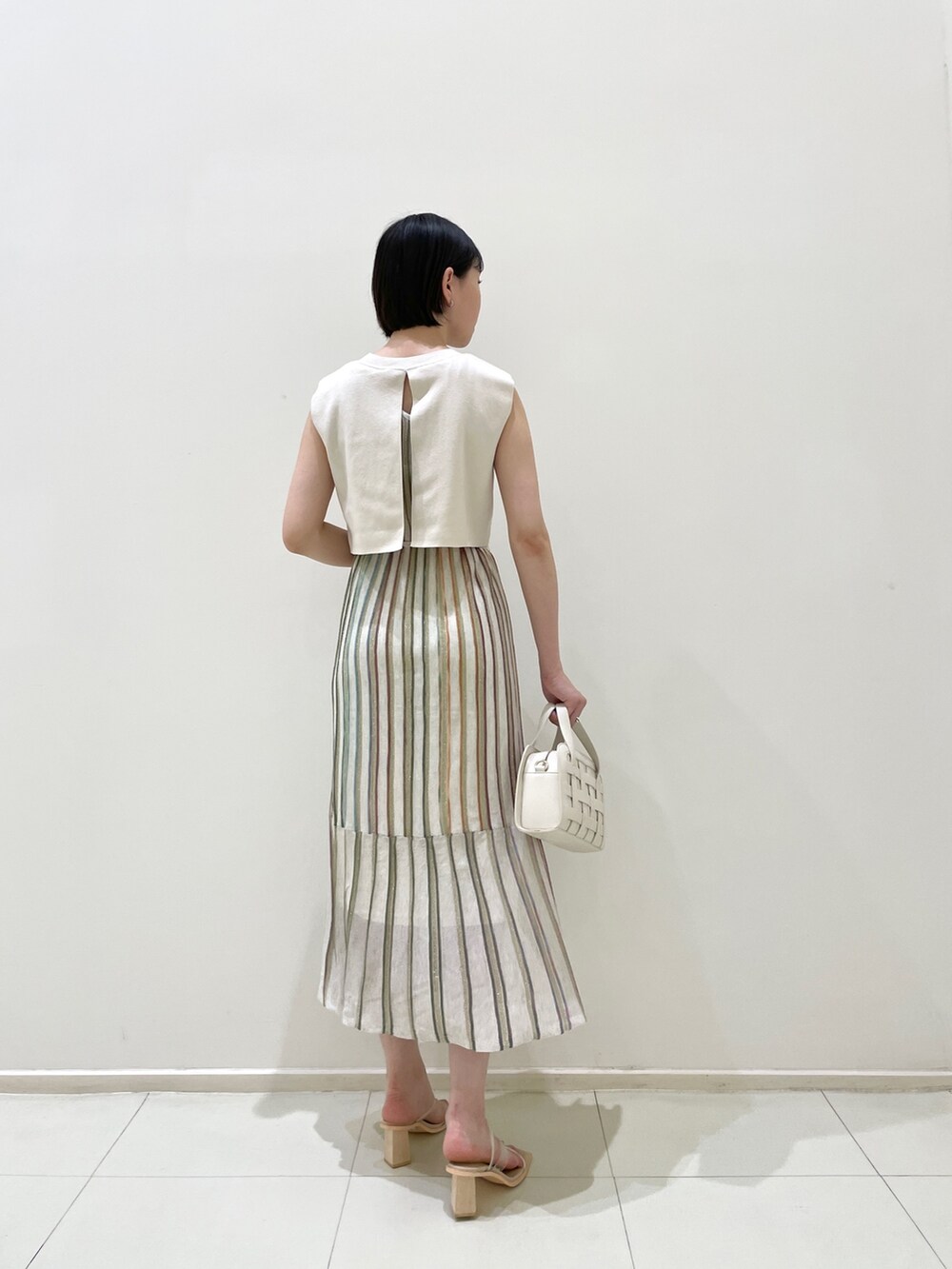 ブルー系のテーラードジャケット、ホワイト系のワンピース、ホワイト系のショルダーバッグを着用したレディースの春コーディネートの7枚目の写真