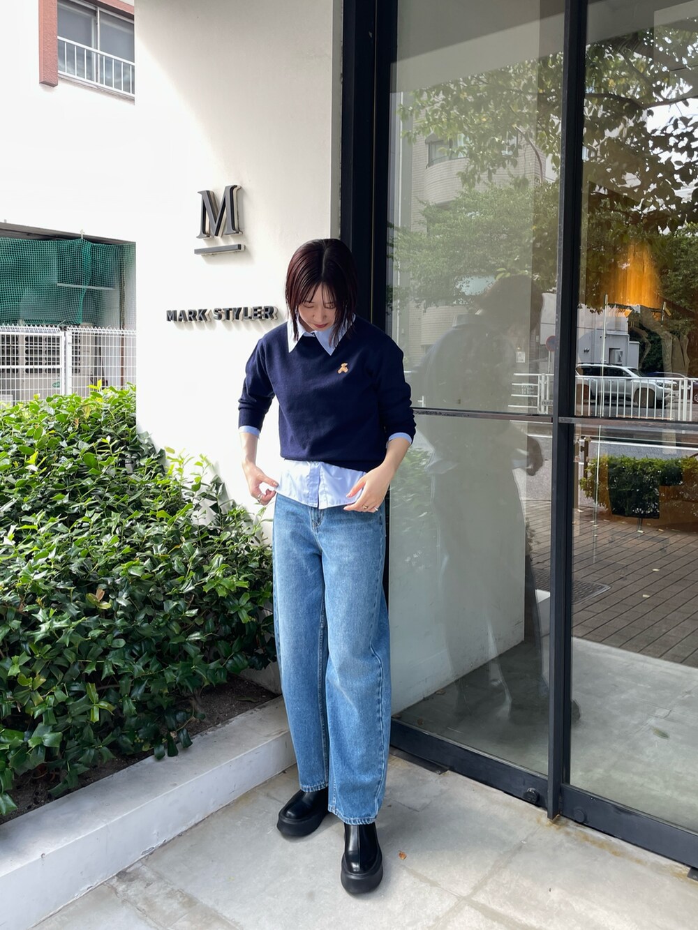 ブルー系のデニムパンツ、ブラック系のブーツ、ブルー系のニット/セーターを着用したレディースの秋コーディネートの3枚目の写真