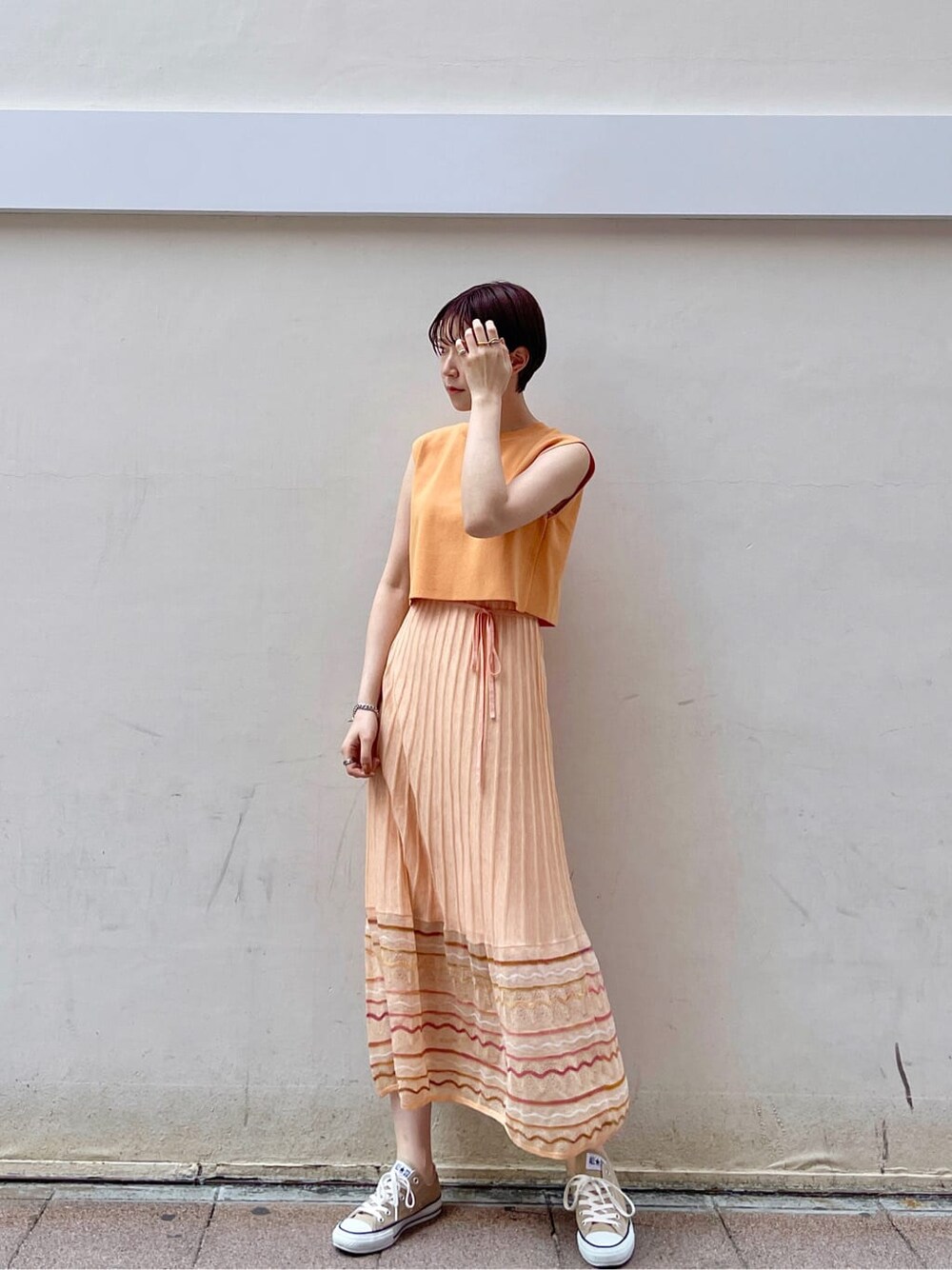 ホワイト系のテーラードジャケット、オレンジ系のワンピースを着用したレディースの春コーディネートの5枚目の写真