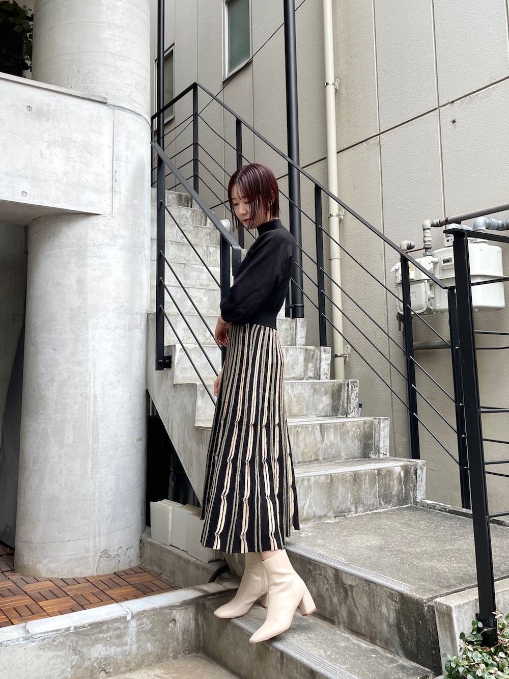 ホワイト系のブーツ、ブラック系のワンピース、グレー系のノーカラーコートを着用したレディースの冬コーディネートの3枚目の写真