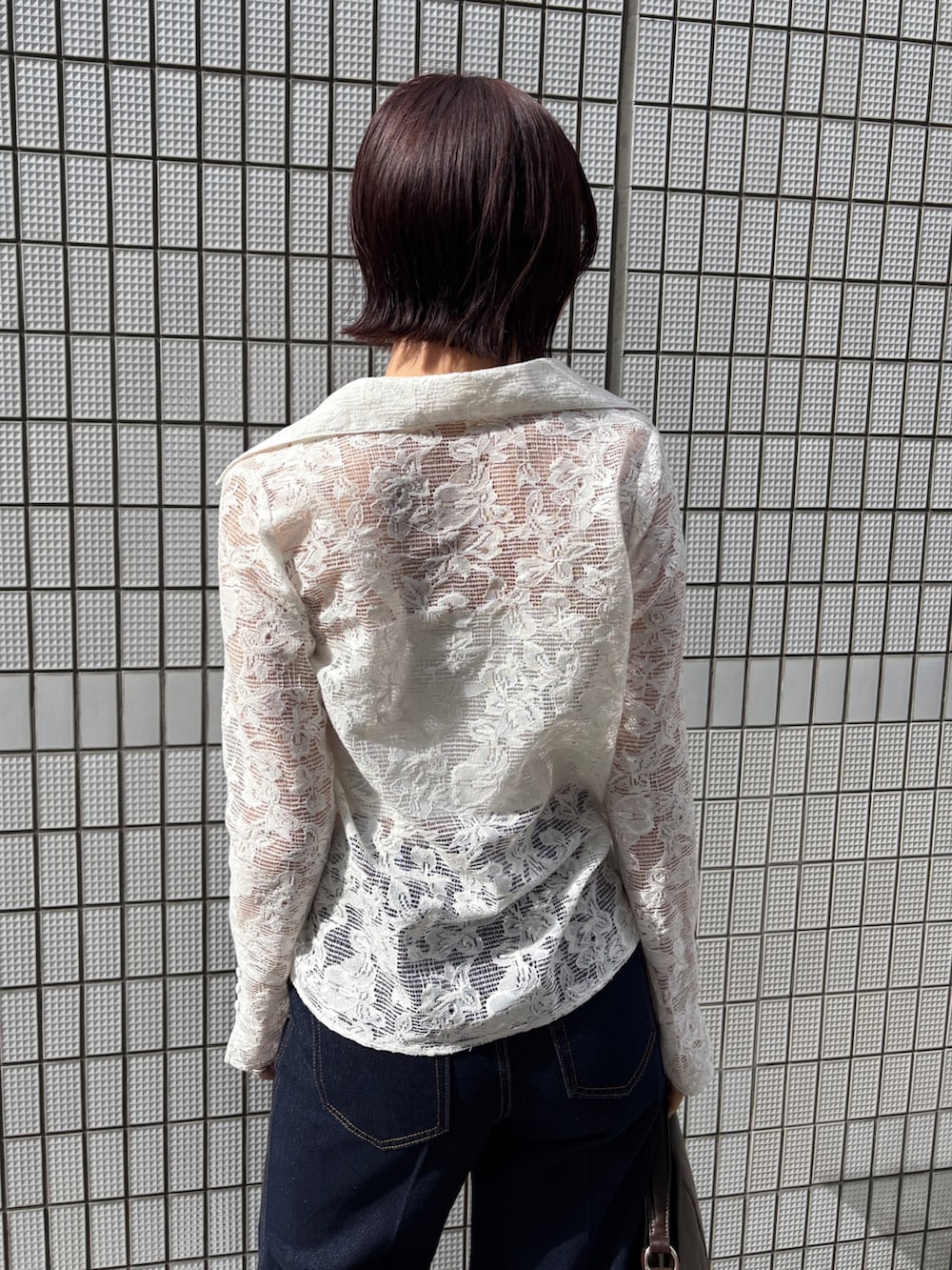 ブルー系のデニムパンツ、ベージュ系のトレンチコート、ホワイト系のシャツ/ブラウスを着用したレディースの冬コーディネートの6枚目の写真