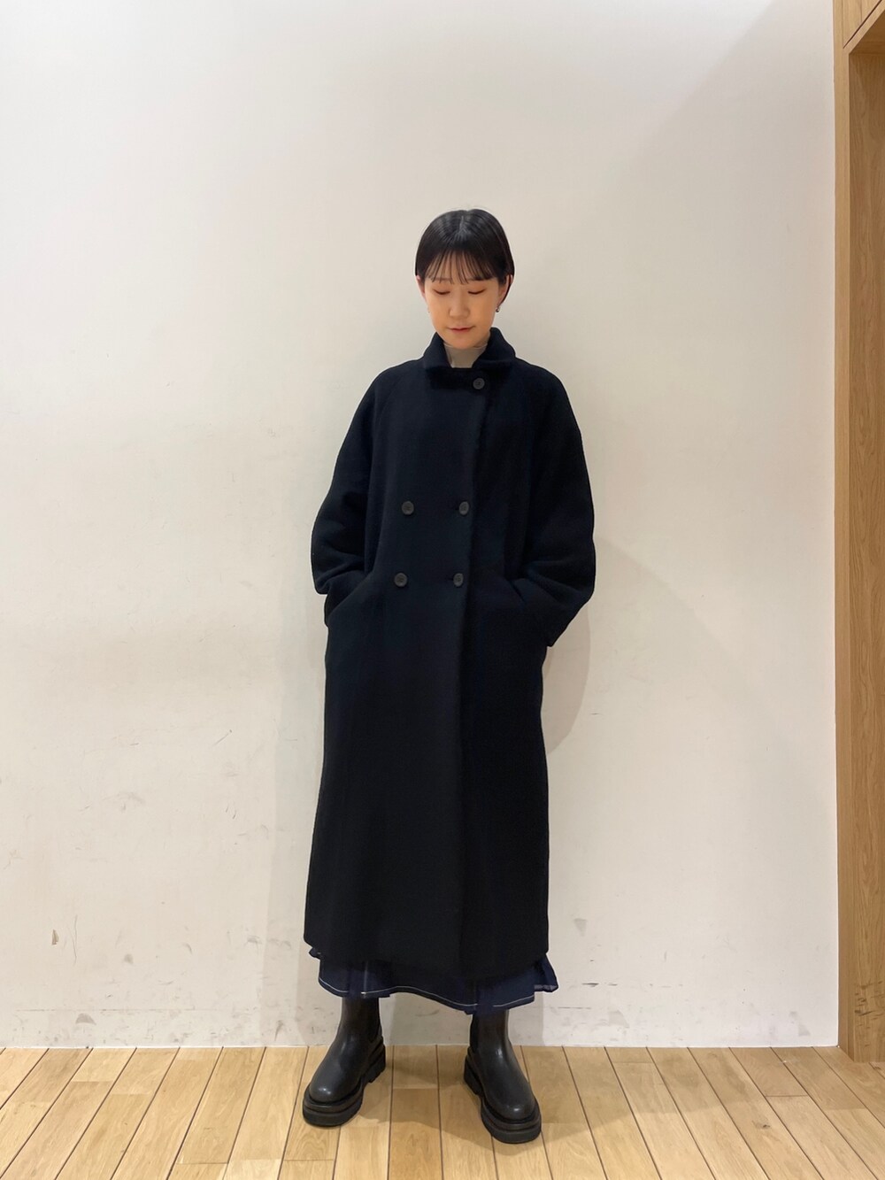 ブラック系のその他アウター、ホワイト系のニット/セーター、ブルー系のスカートを着用したレディースの冬コーディネートの7枚目の写真