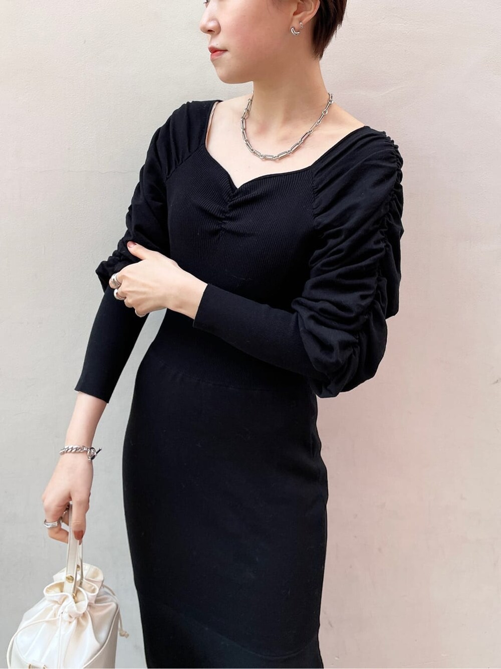 ブラック系のワンピース、ホワイト系のハンドバッグ、ホワイト系のその他シューズを着用したレディースの冬コーディネートの5枚目の写真