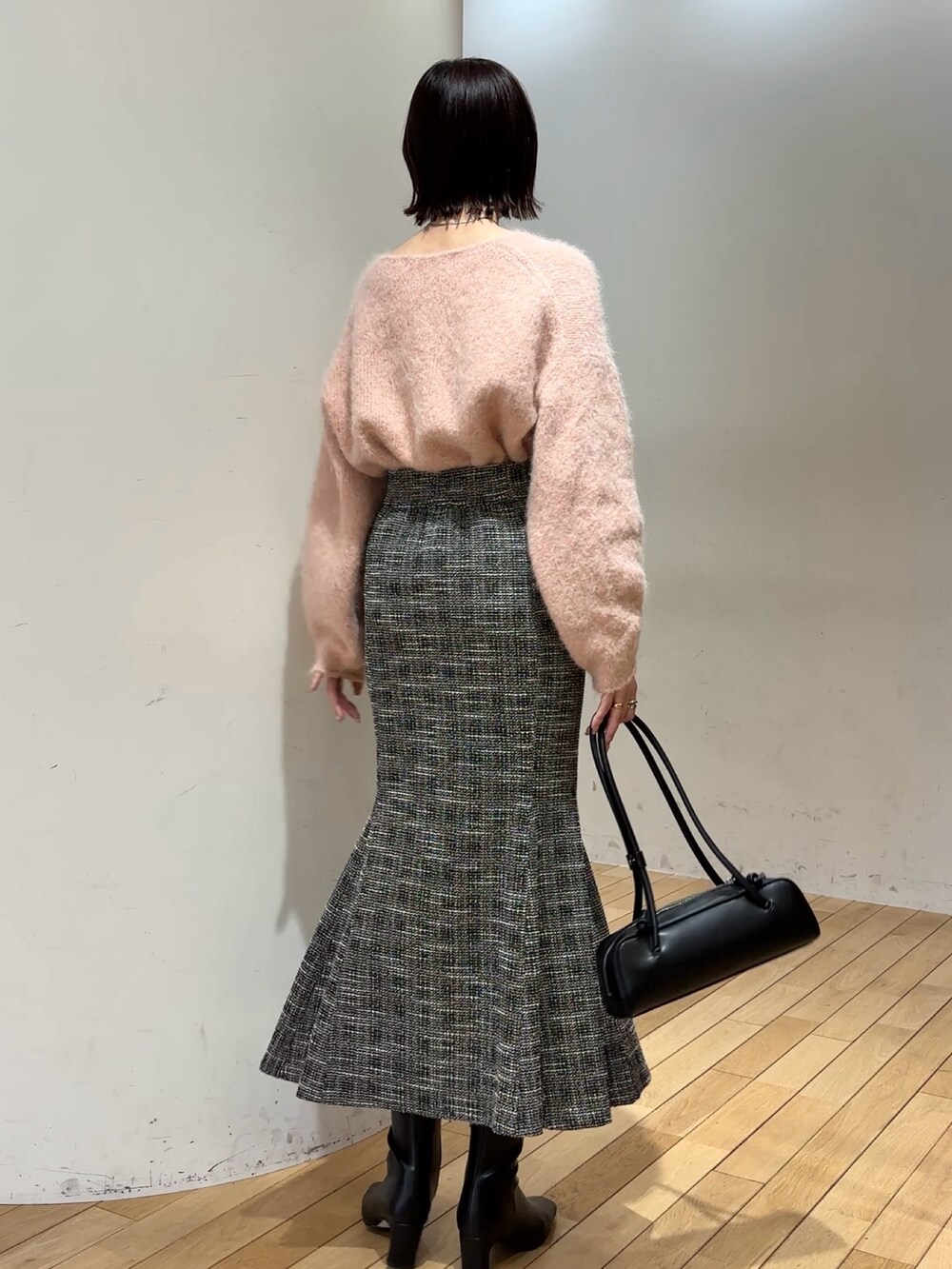 ブラック系のブーツ、ピンク系のニット/セーター、ブラック系のショルダーバッグを着用したレディースの冬コーディネートの5枚目の写真
