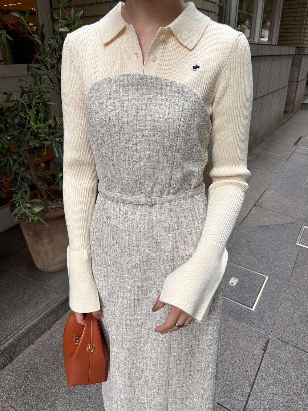 ホワイト系のワンピース、ブラウン系のハンドバッグ、ブラック系のブーツを着用したレディースの秋コーディネートの7枚目の写真