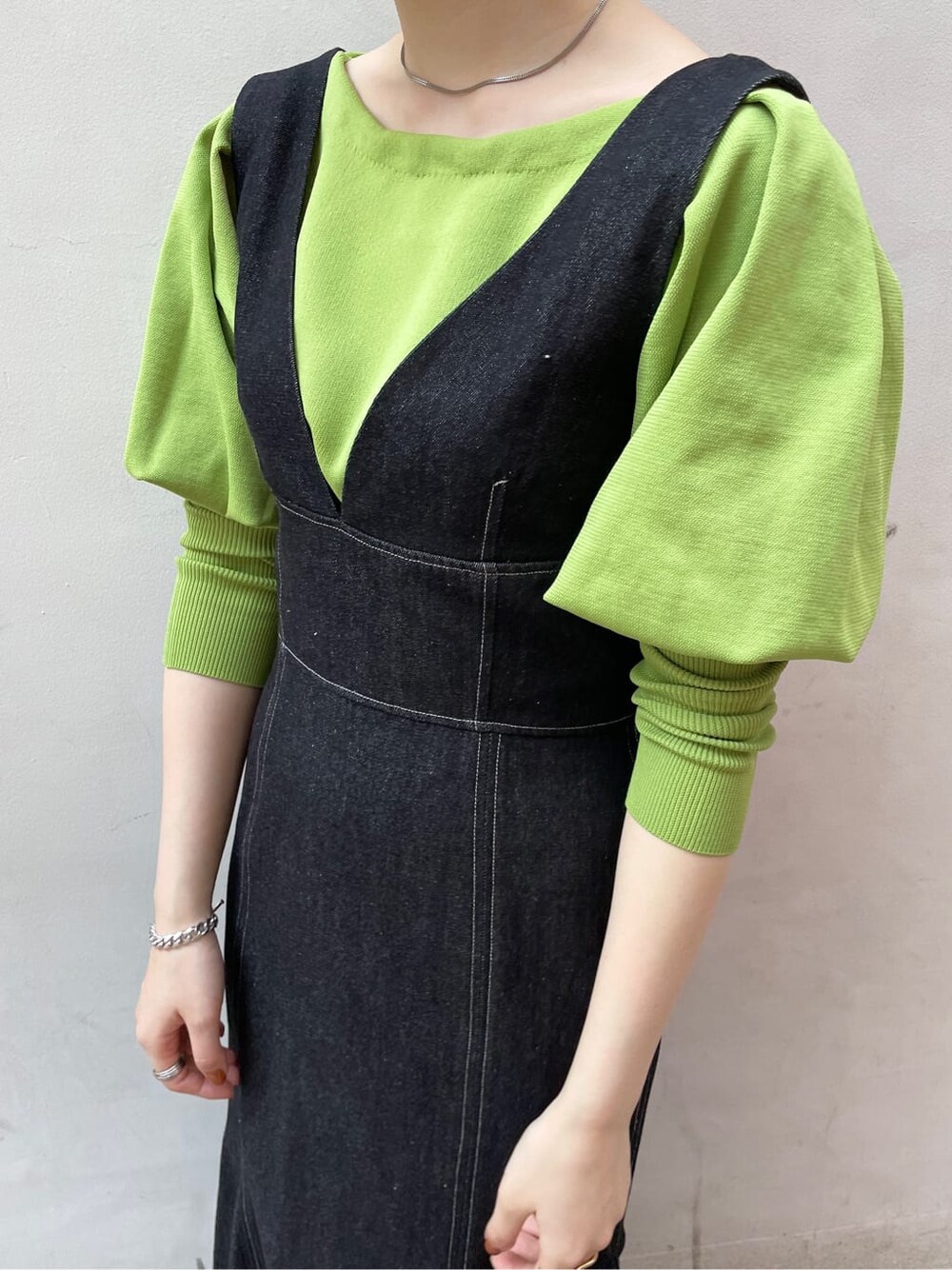 ブラック系のワンピース、グリーン系のニット/セーター、ブラック系のサンダルを着用したレディースの春コーディネートの7枚目の写真