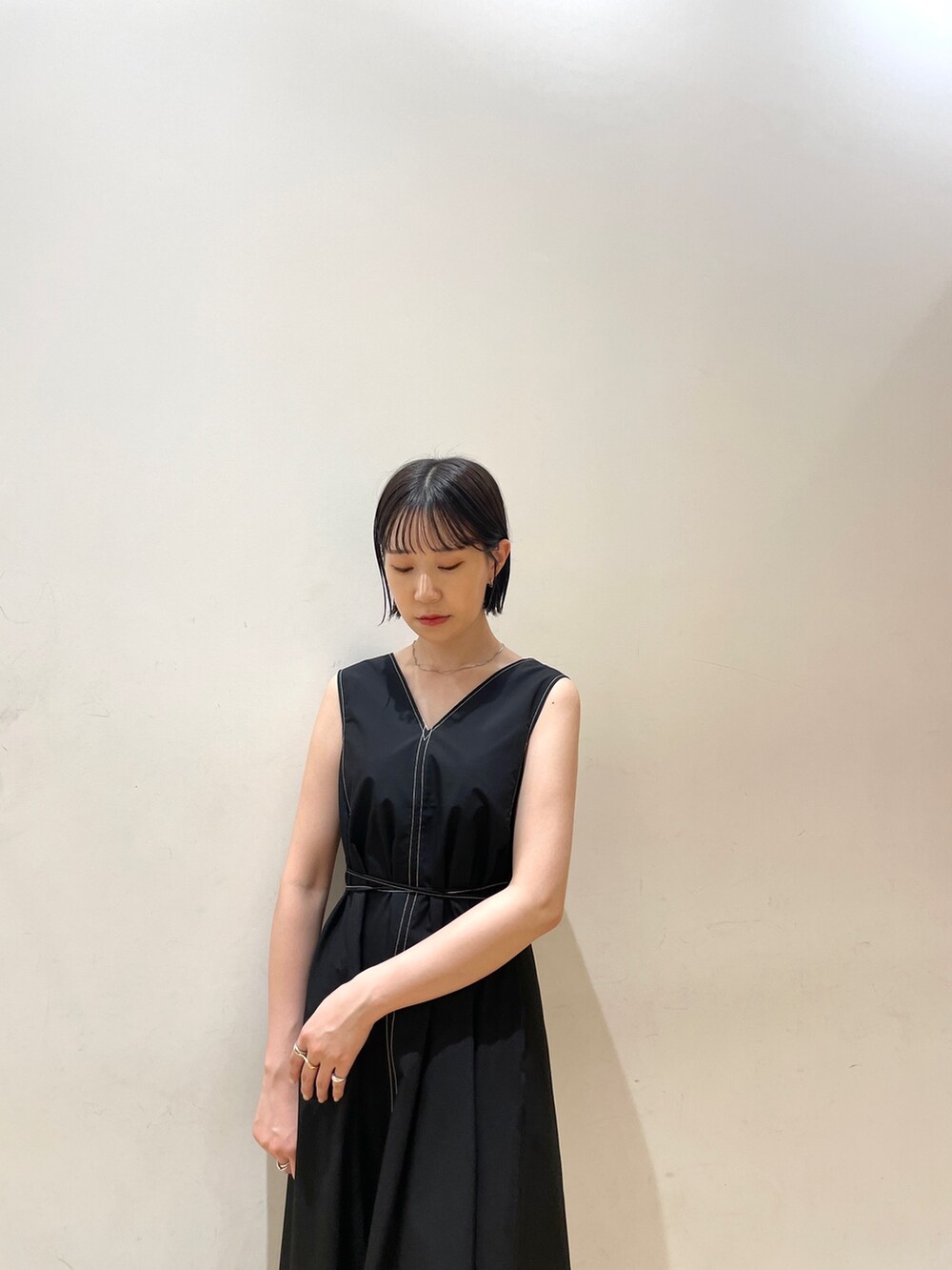 ブラック系のワンピース、ホワイト系のハンドバッグ、ホワイト系のネックレスを着用したレディースの夏コーディネートの7枚目の写真