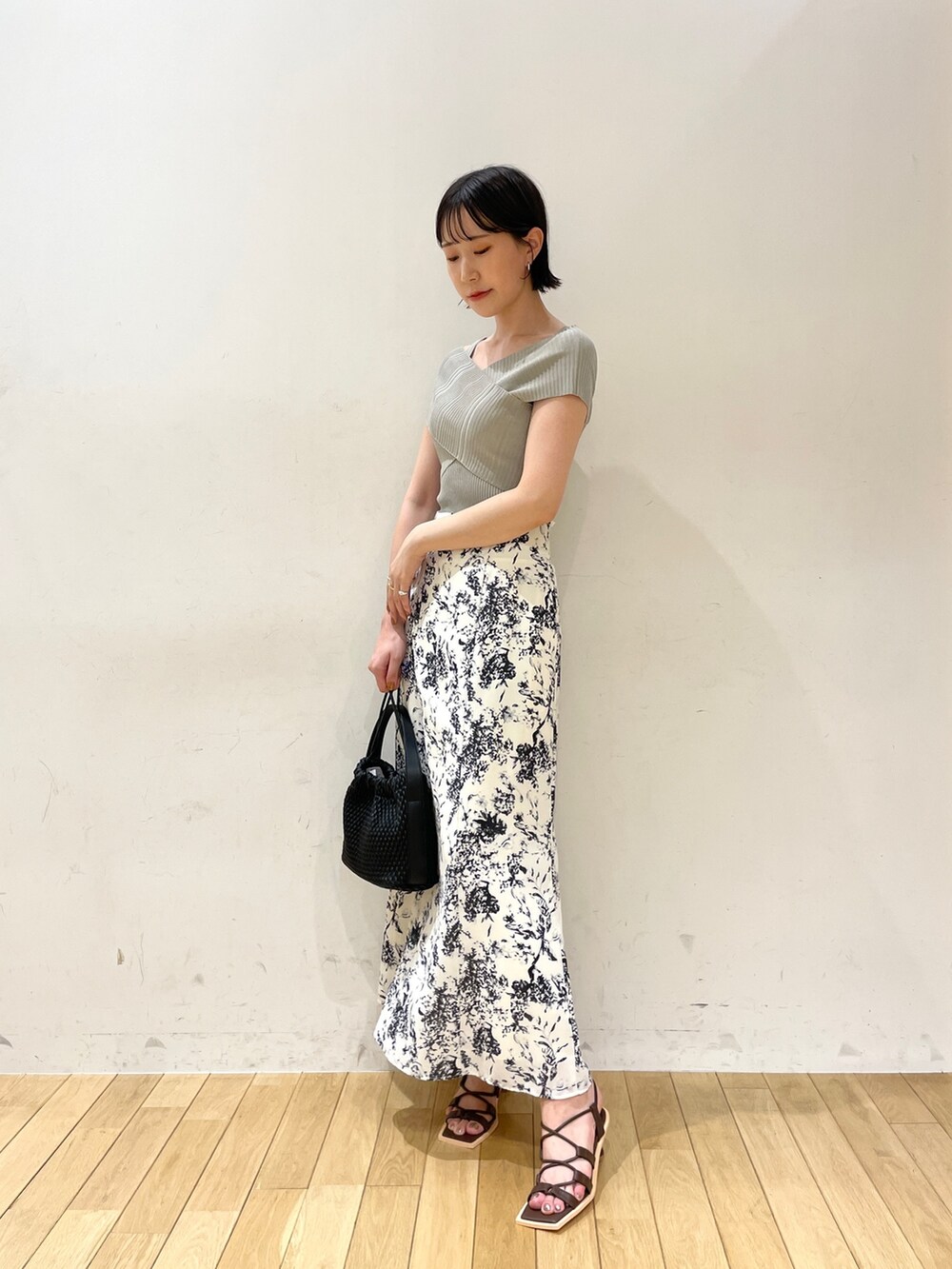 グリーン系のニット/セーター、ブルー系のスカート、ブラウン系のサンダルを着用したレディースの夏コーディネートの2枚目の写真