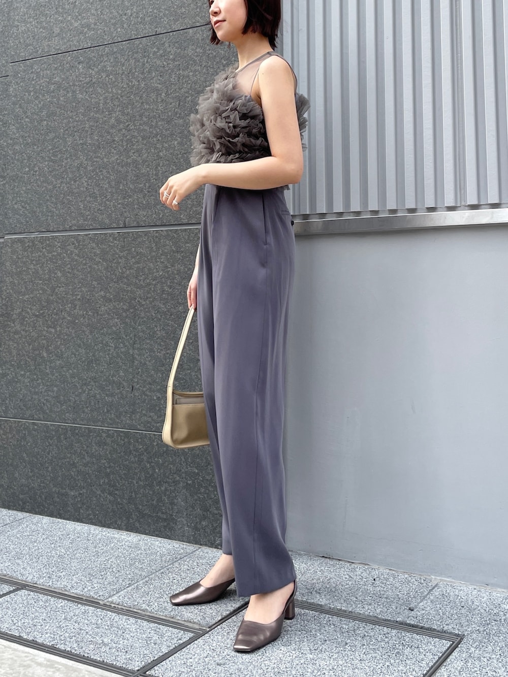 その他のパンプス、グレー系のパンツドレス、ベージュ系のハンドバッグを着用したレディースの春コーディネートの7枚目の写真