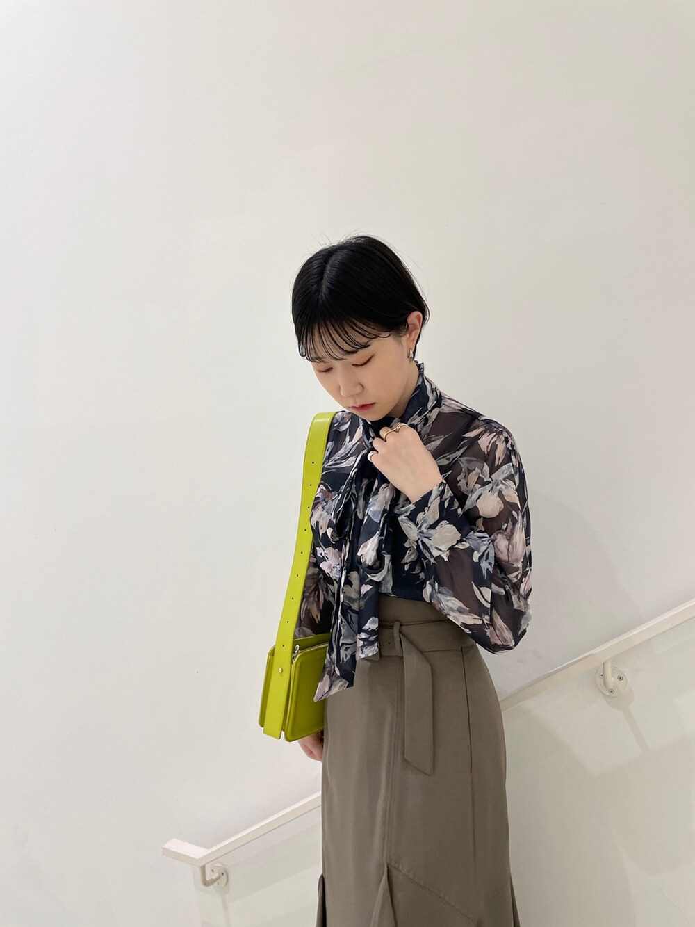 ブラウン系のスカート、ブルー系のシャツ/ブラウス、グリーン系のショルダーバッグを着用したレディースの春コーディネートの5枚目の写真