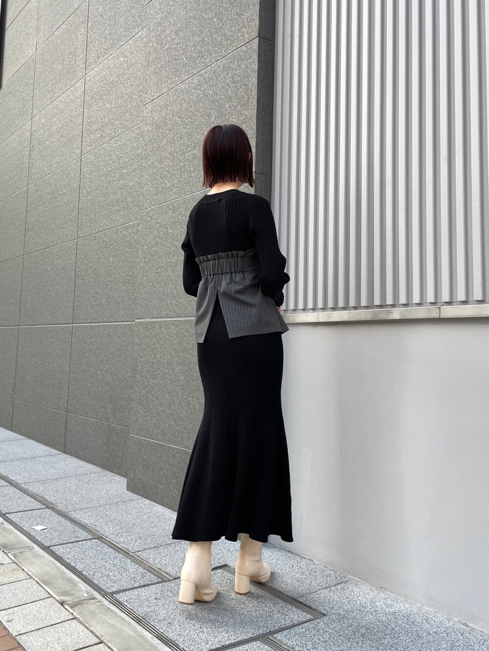 ホワイト系のブーツ、ブラック系のワンピース、ホワイト系のブルゾンを着用したレディースの冬コーディネートの4枚目の写真