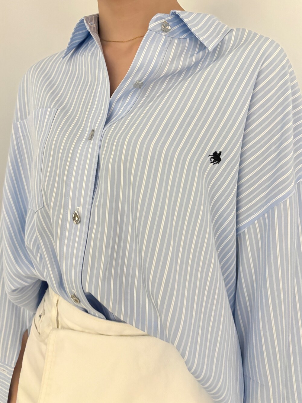 ブルー系のシャツ/ブラウス、ホワイト系のデニムパンツ、ホワイト系のサンダルを着用したレディースの冬コーディネートの6枚目の写真