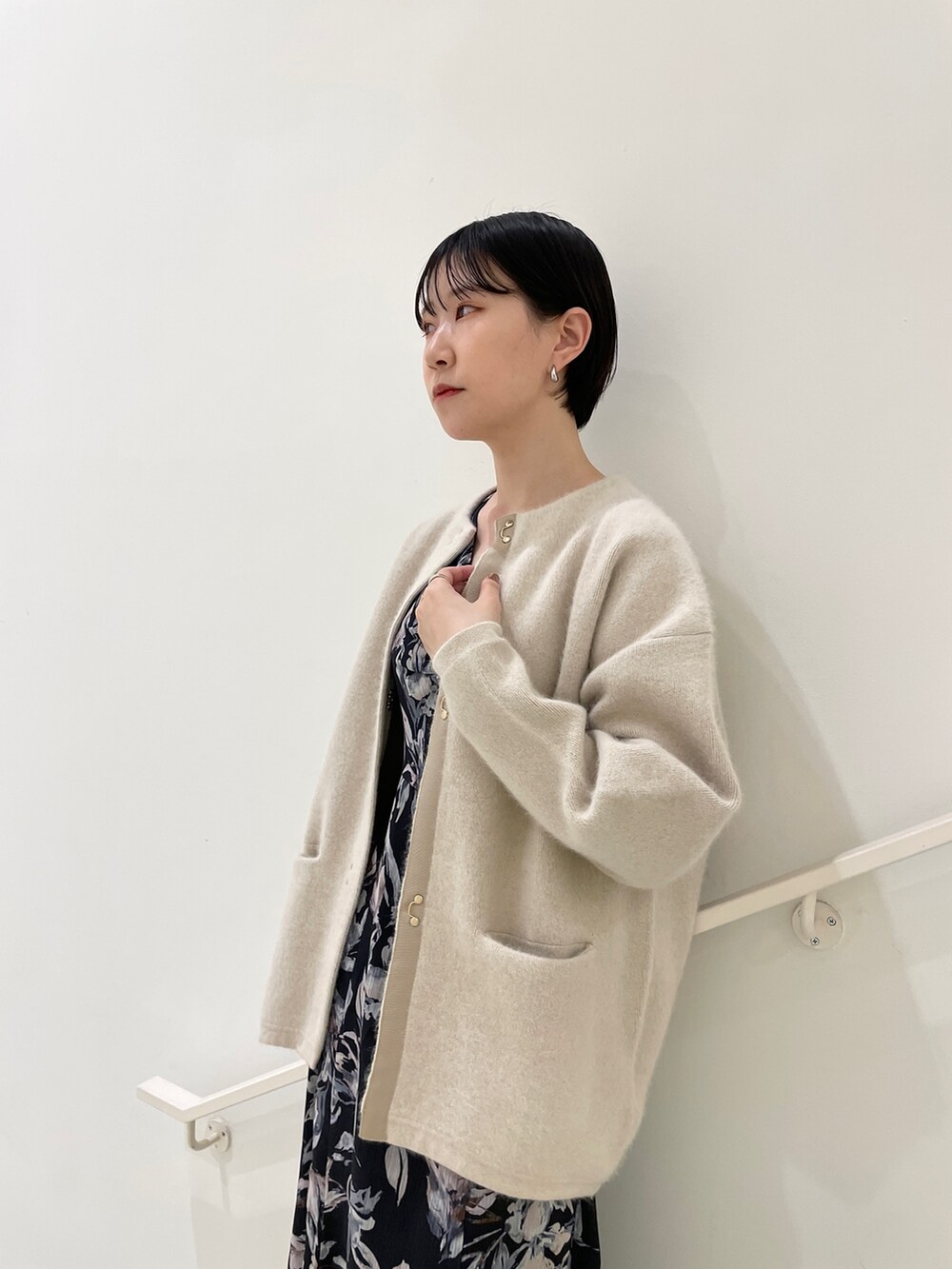 ホワイト系のカーディガン/ボレロ、ブルー系のワンピース、ブラック系のブーツを着用したレディースの冬コーディネートの6枚目の写真