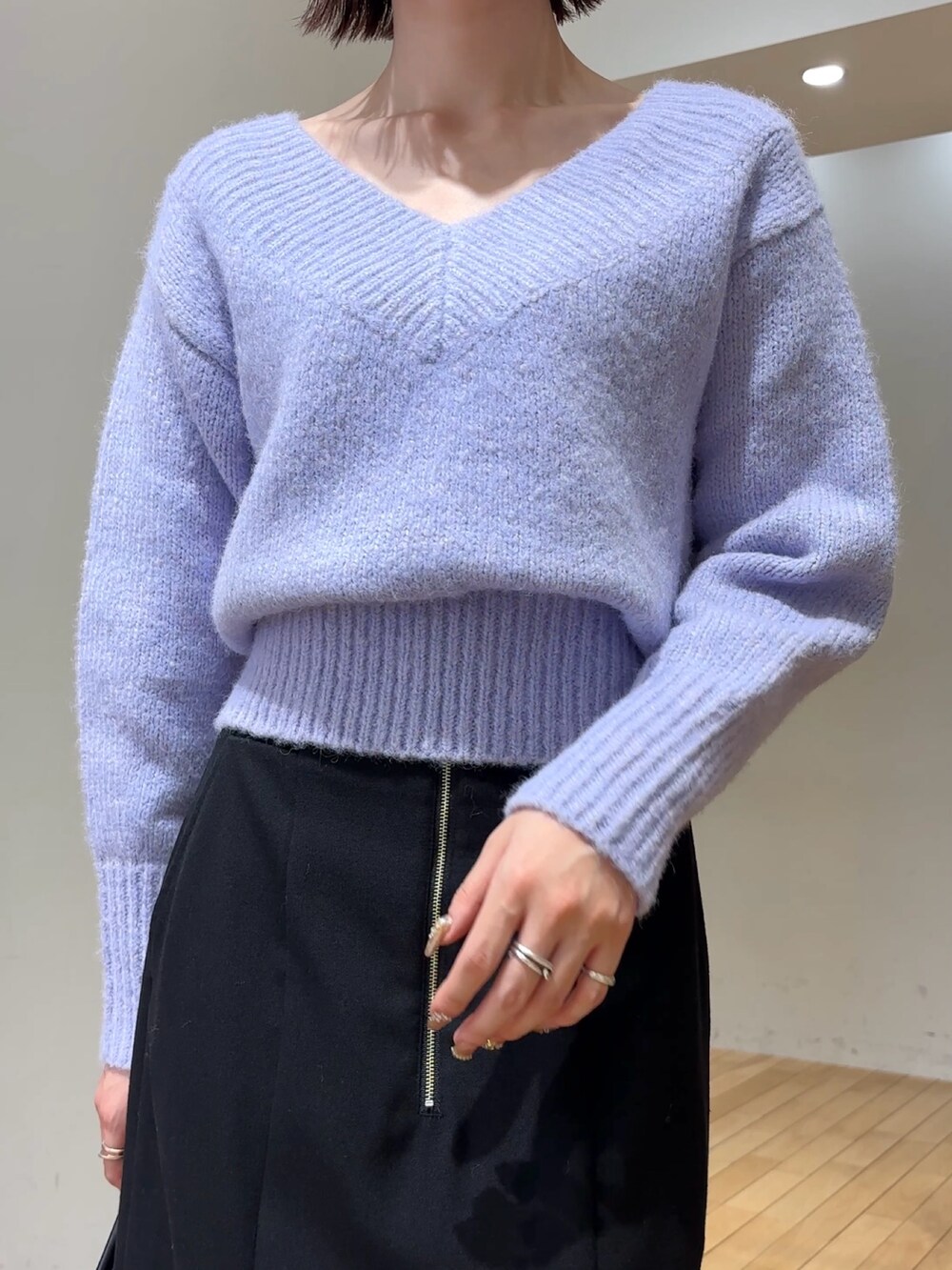 ブラック系のスカート、パープル系のニット/セーター、ブラック系のショルダーバッグを着用したレディースの冬コーディネートの7枚目の写真