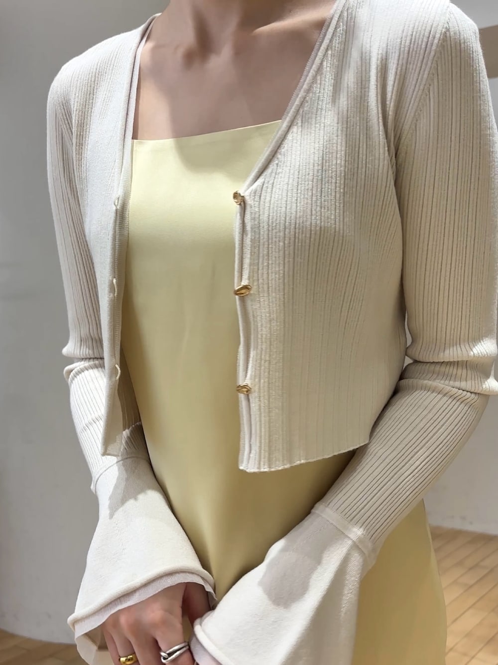 ホワイト系のワンピース、ホワイト系のサンダル、ブルー系のアンサンブルを着用したレディースの春コーディネートの6枚目の写真