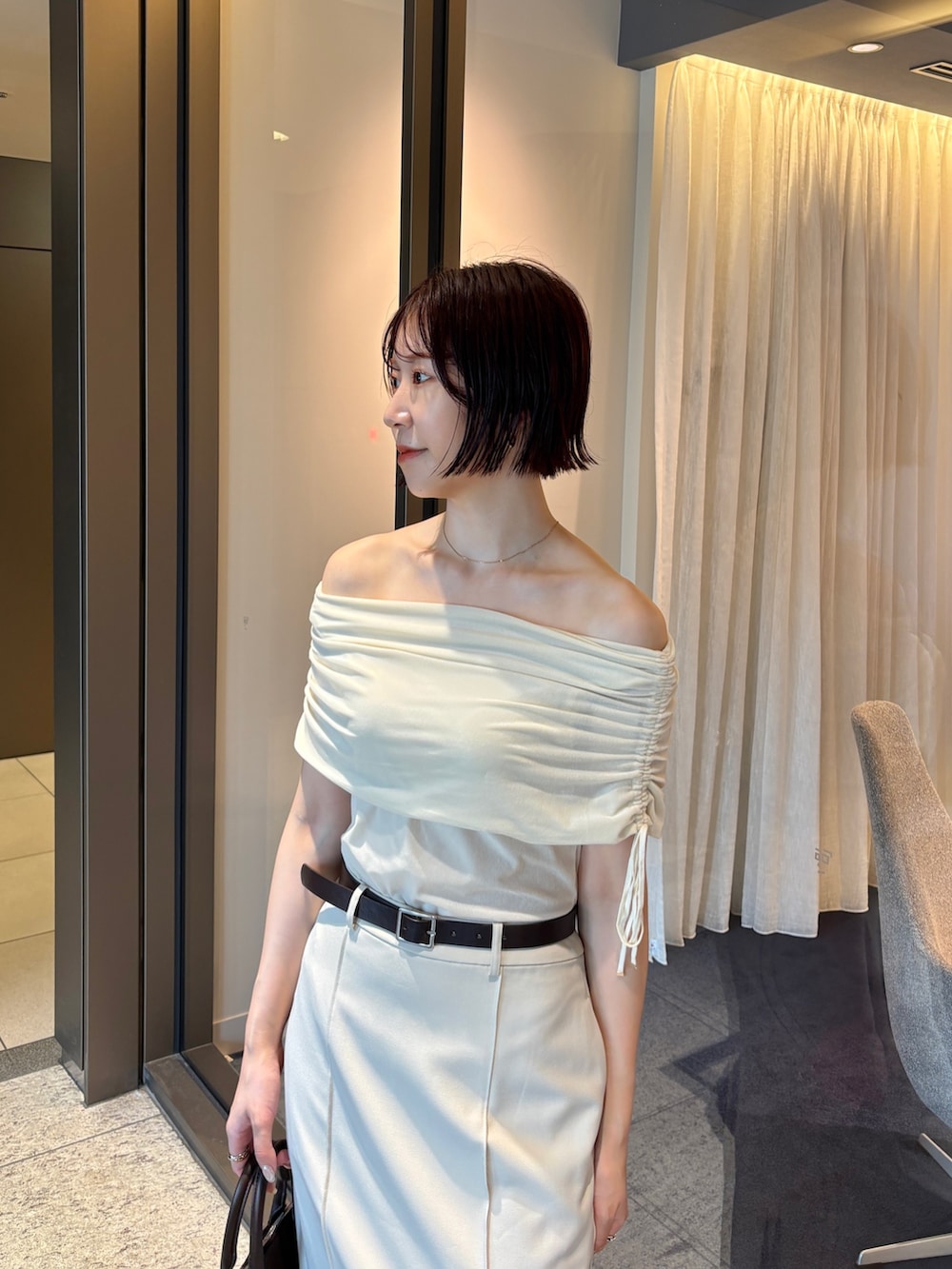 ホワイト系のスカート、ホワイト系のTシャツ/カットソー、ブラウン系のパンプスを着用したレディースの秋コーディネートの5枚目の写真