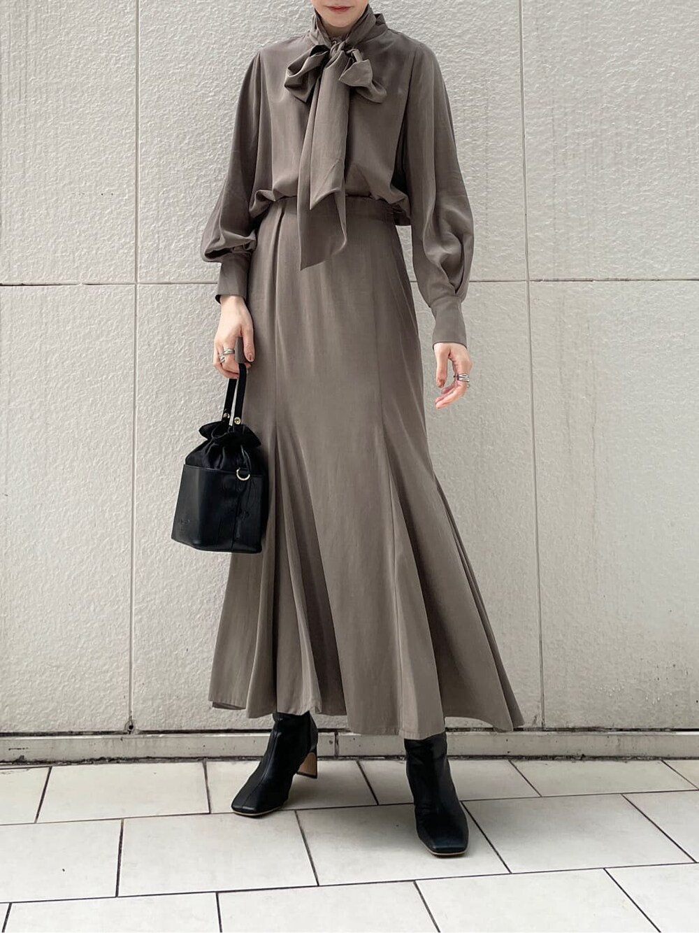 ブラック系のその他シューズ、ホワイト系のその他アウター、ブラウン系のシャツ/ブラウスを着用したレディースの冬コーディネートの2枚目の写真