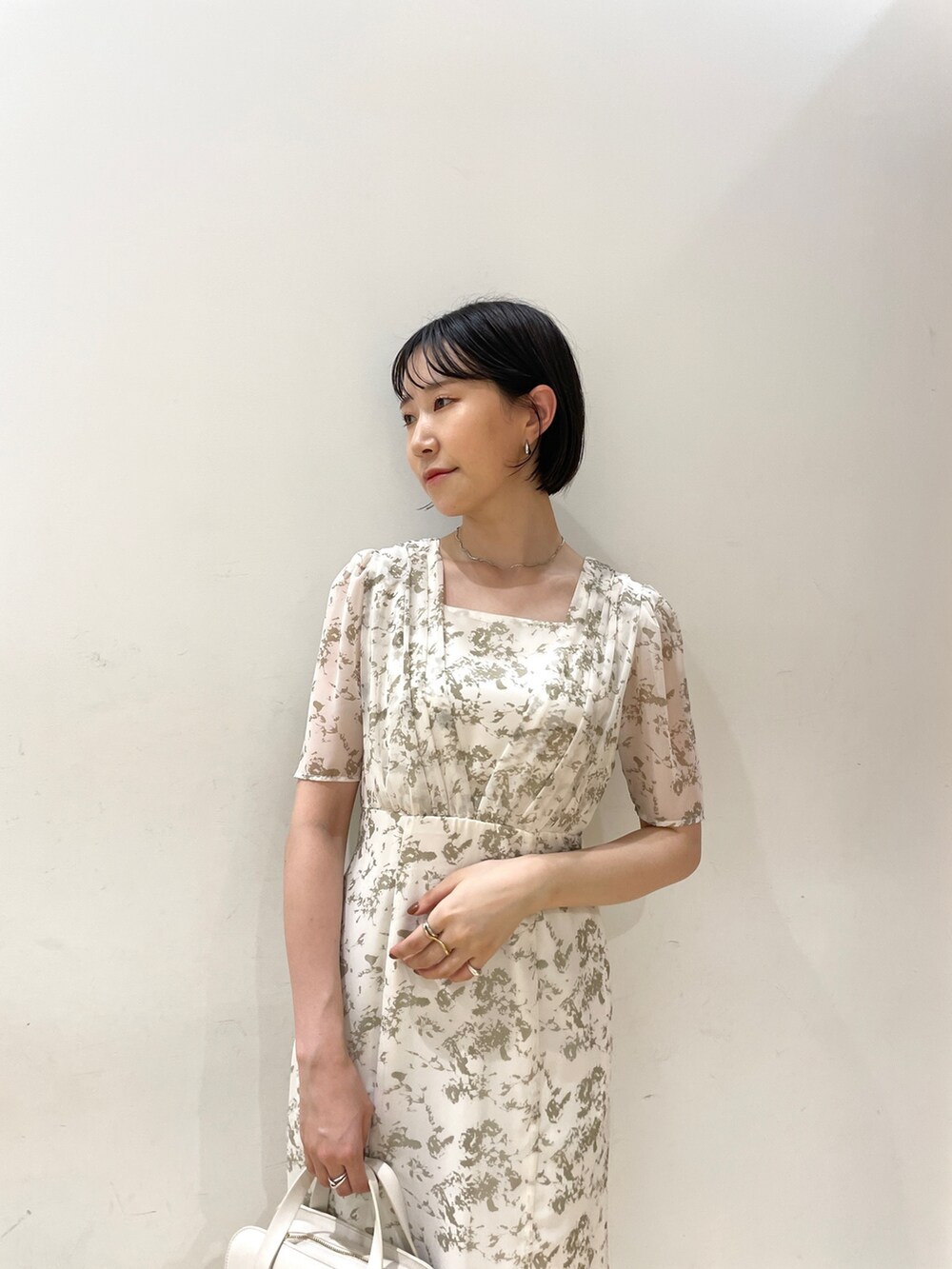 ホワイト系のワンピース、ホワイト系のショルダーバッグ、ベージュ系のサンダルを着用したレディースの夏コーディネートの6枚目の写真