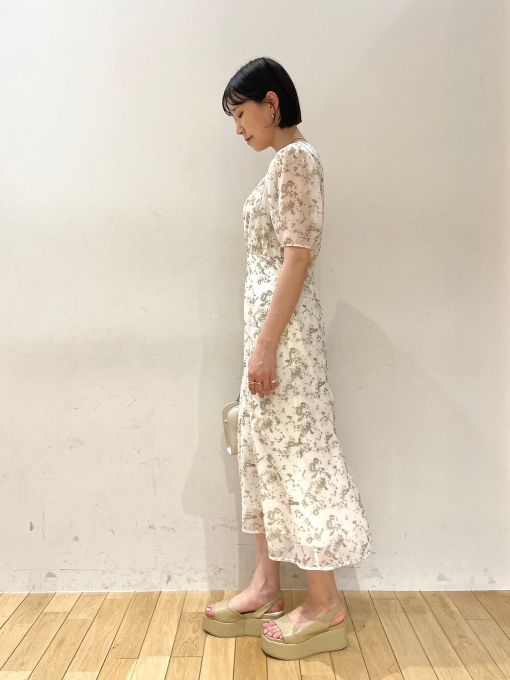 ホワイト系のワンピース、ホワイト系のショルダーバッグ、ベージュ系のサンダルを着用したレディースの夏コーディネートの3枚目の写真